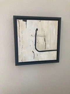 Abstract wall art with black lines on a white background in a black frame.