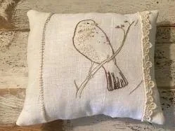 Decorative pillow with embroidered bird design and lace trim