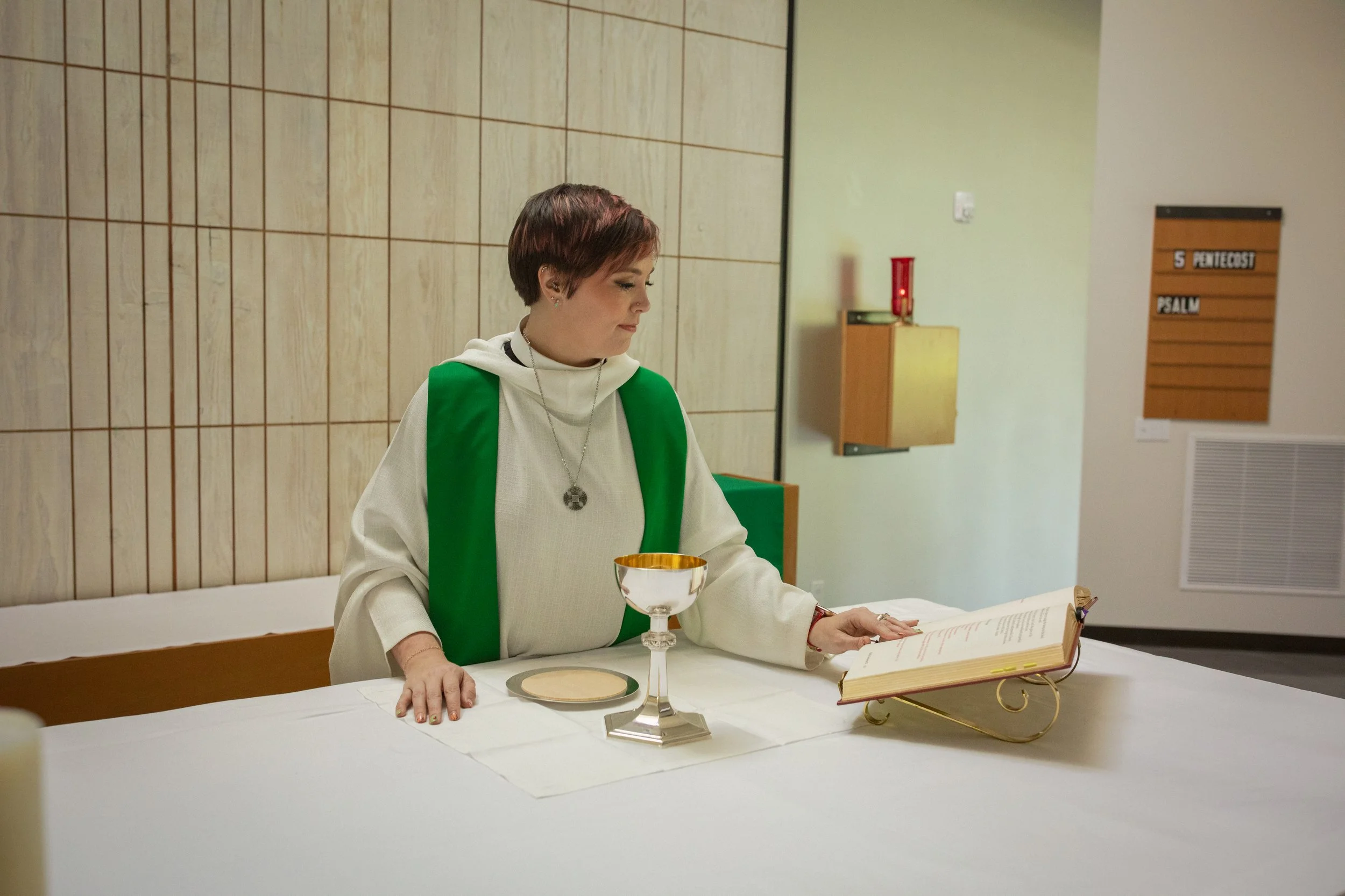 a picture of a woman dressed in priestly vestments preparing for holy communion