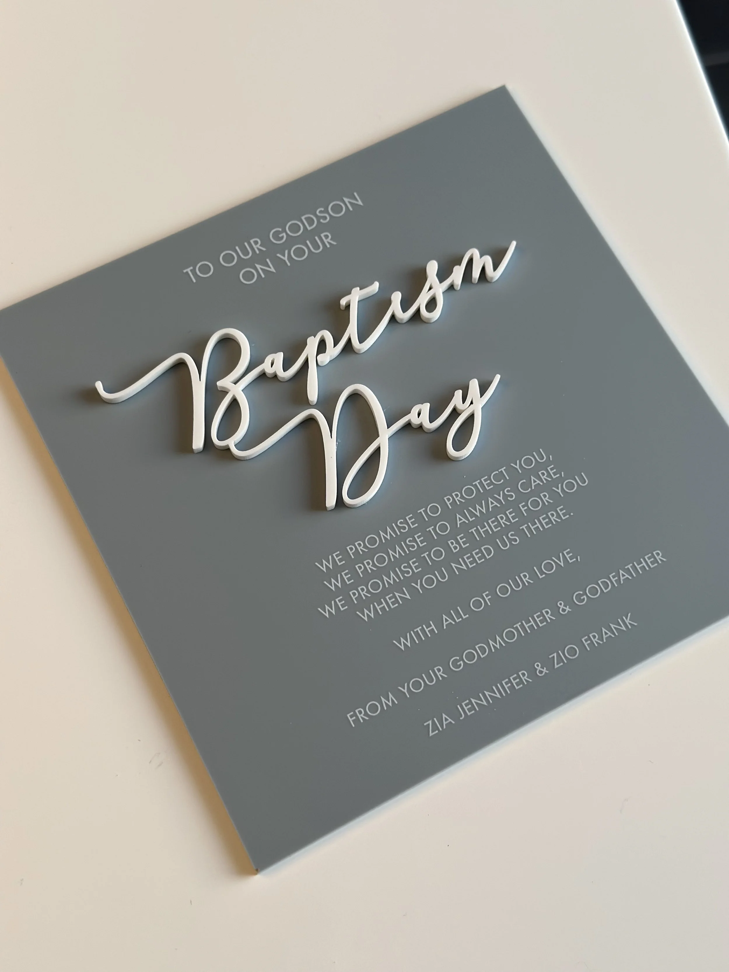 A baptism day message with a gray background and white text, featuring a 3D script of the words 'Baptism Day'.