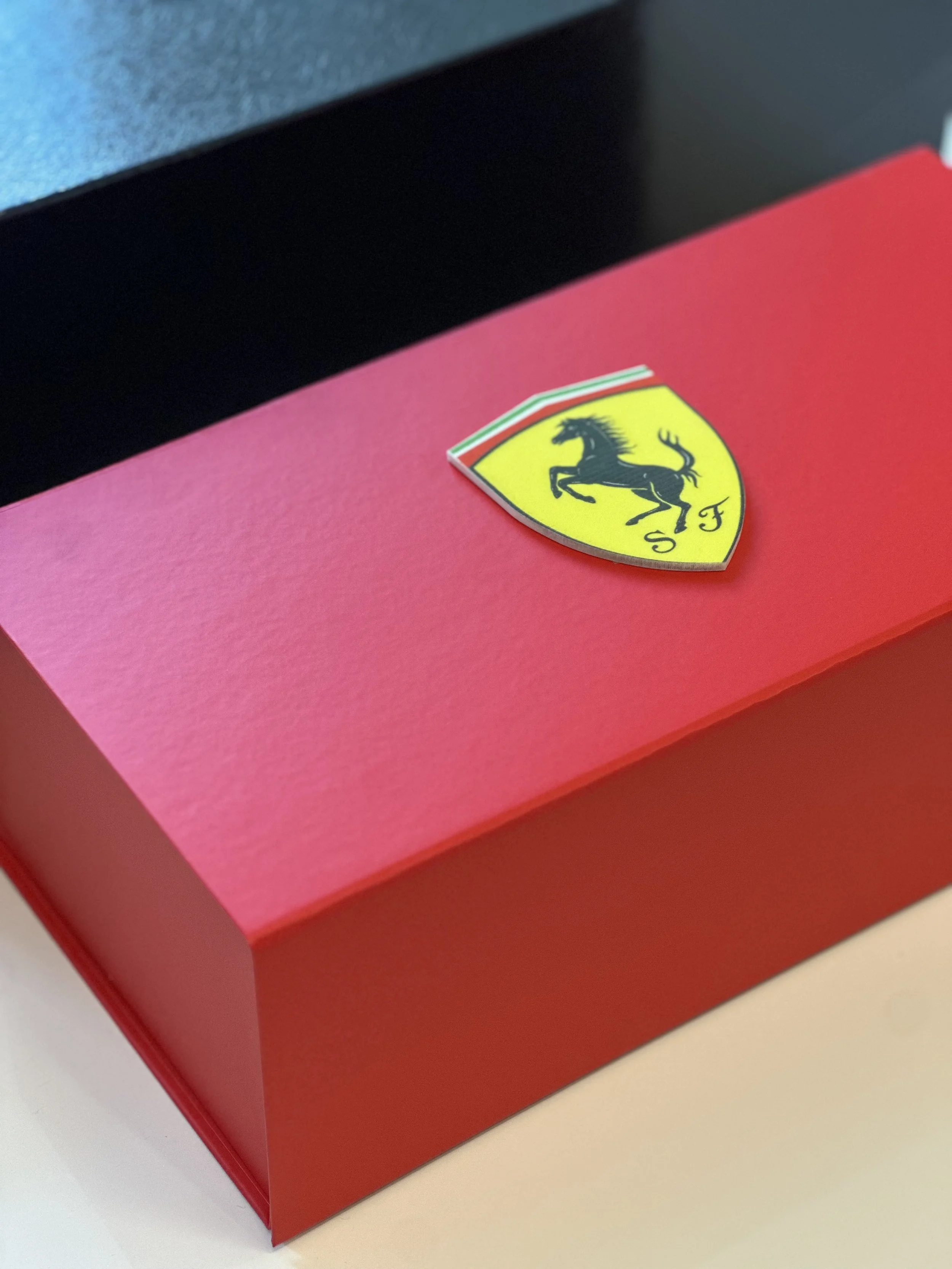 Red Ferrari box with Ferrari emblem logo on the top.
