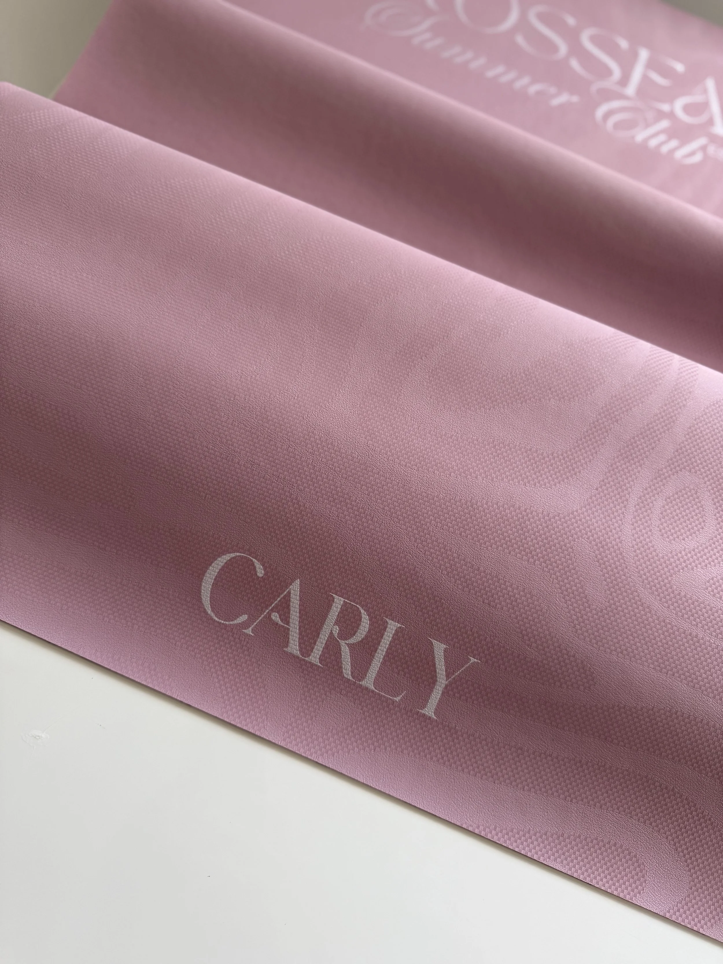 A pink packaging paper with the word 'CARY' printed on it in white letters.