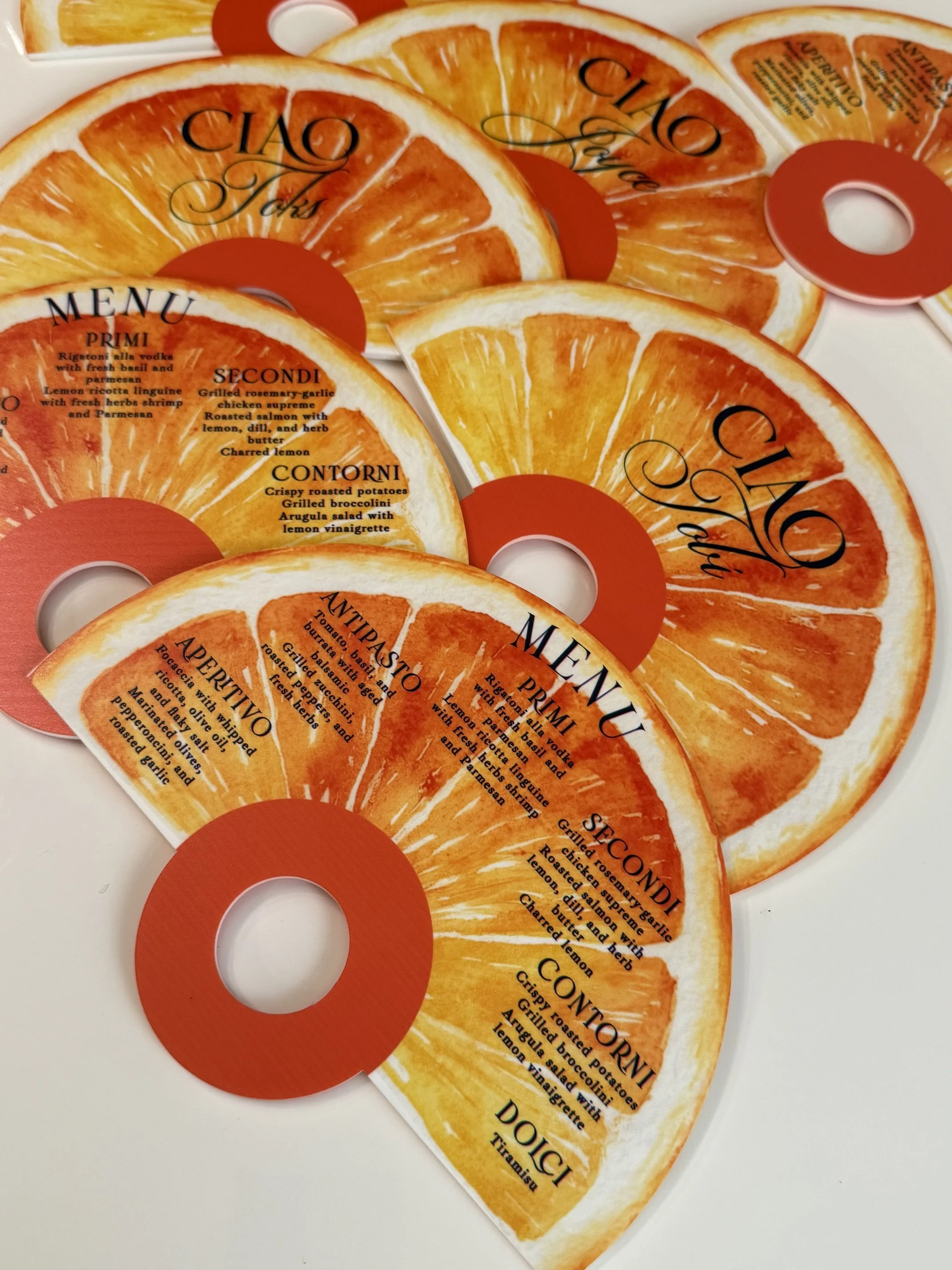 Packaging of orange slices resembling a fruit slice with a transparent plastic cover, labeled with various menu options and recipes.