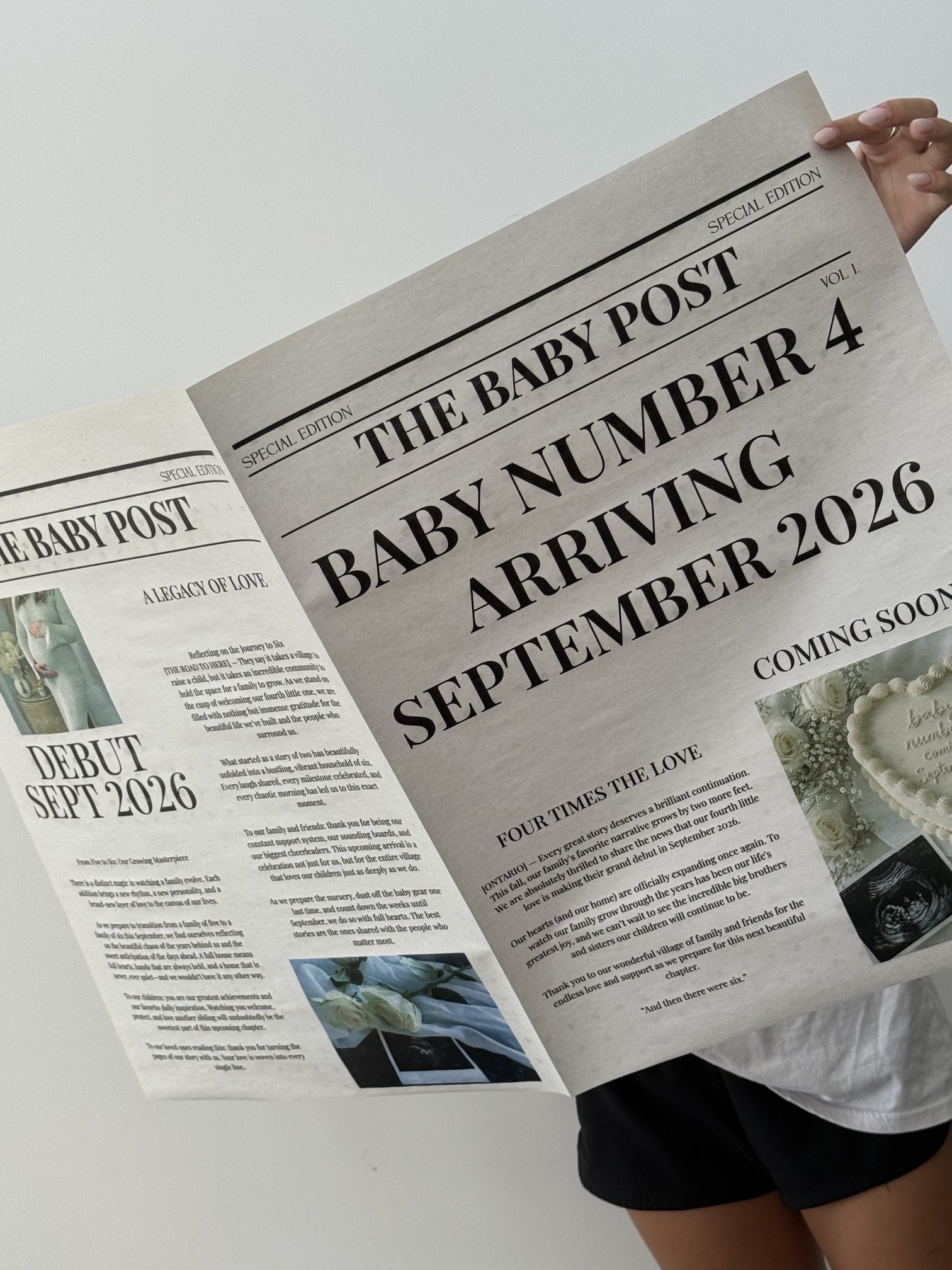 A person holding a newspaper titled 'The Baby Post'. The headline reads 'Baby Number 4 Arrival September 2026'. The newspaper features text and images about a family welcoming a fourth baby in September 2026, and includes photos of flowers and a baby