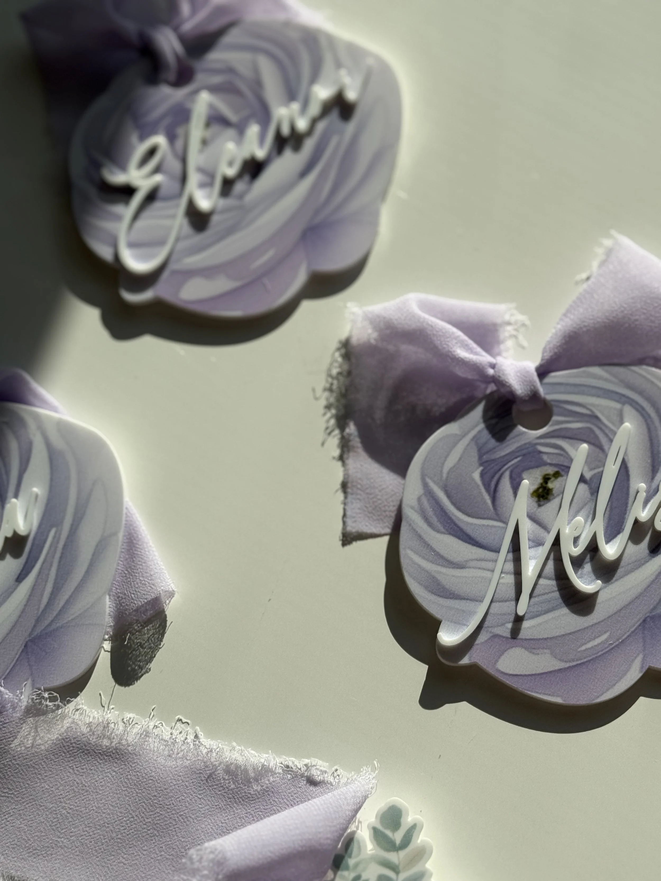 Decorative pieces with lavender-colored ruffles and the word Mello handwritten in script. Small fabric pieces with frayed edges are also visible.