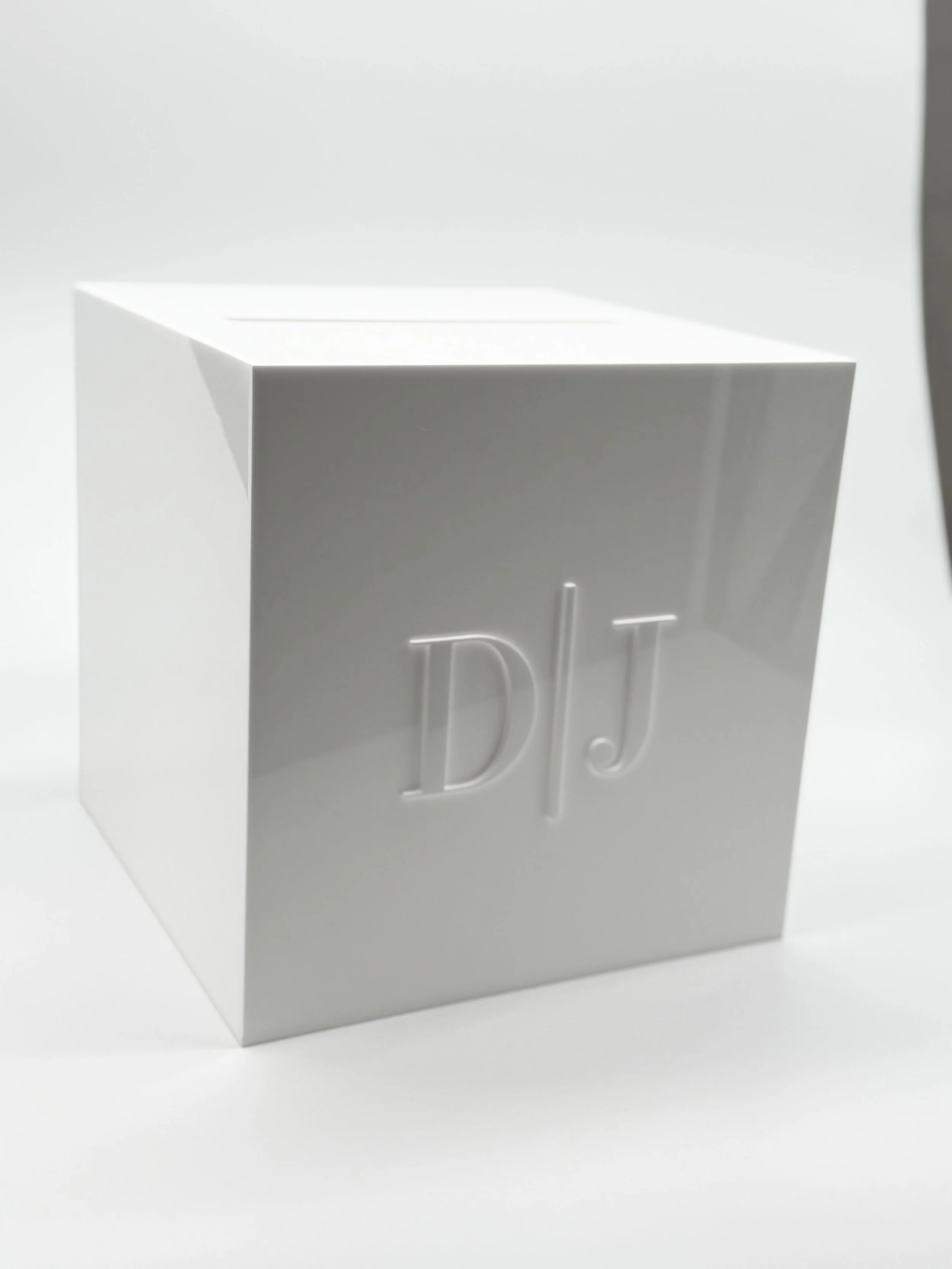 White box with embossed initials "D/J" on the front, set against a white background.