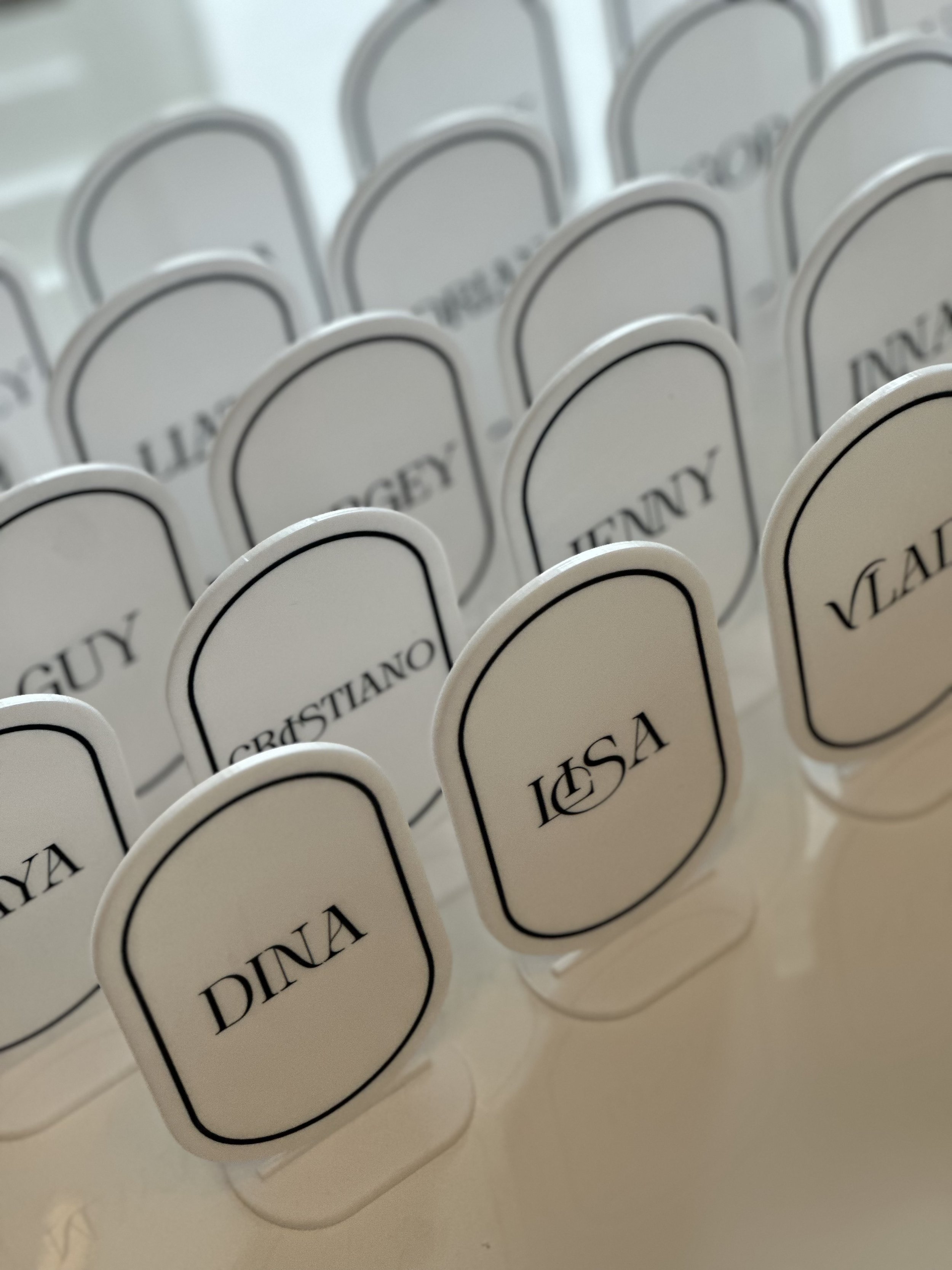 Table markers labeled for a wedding or event, with names such as Dina, Lisa, and Cristiano, arranged in rows.