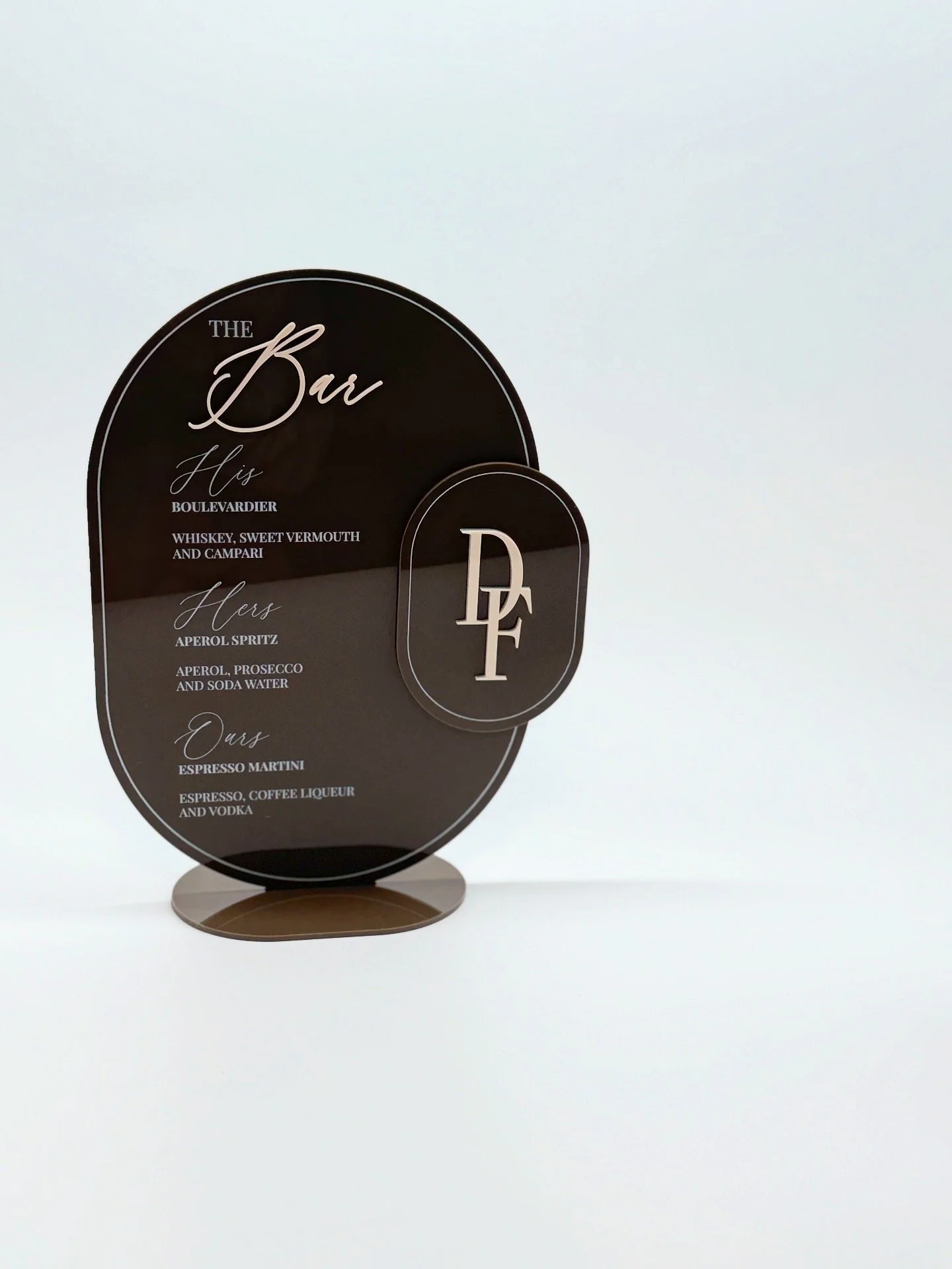 Signage for a bar with list of drinks for him, her, and us, and a logo with the initials D and F