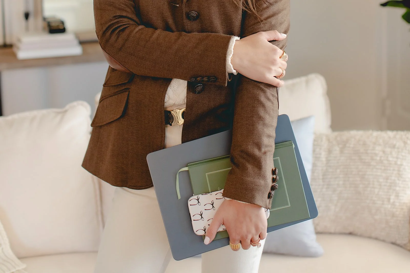 Business owner holding a computer, notebook, and phone
