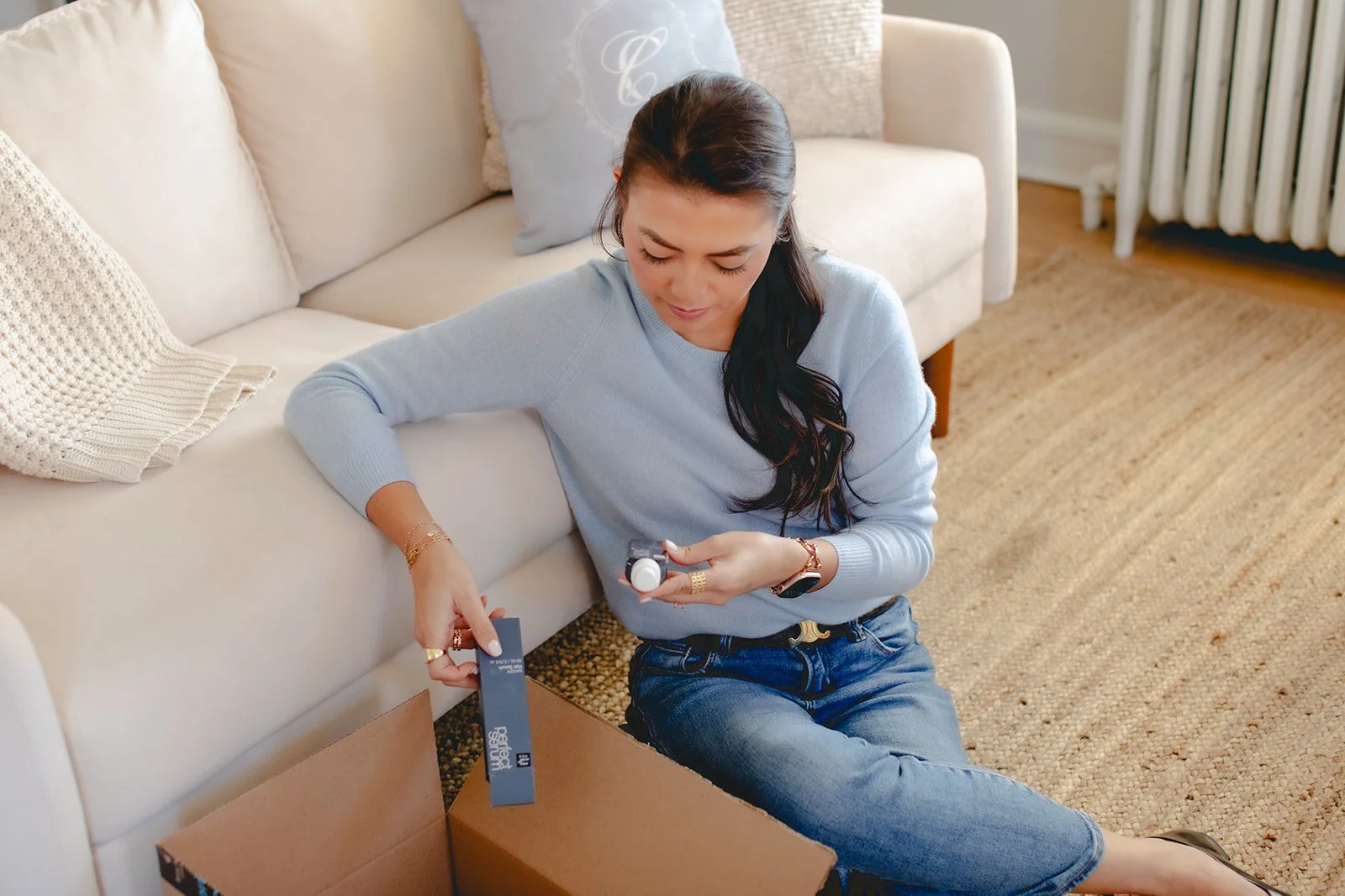 Social media ad strategist sitting on the floor opening various products