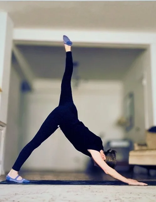 Person doing the downward dog yoga pose indoors.
