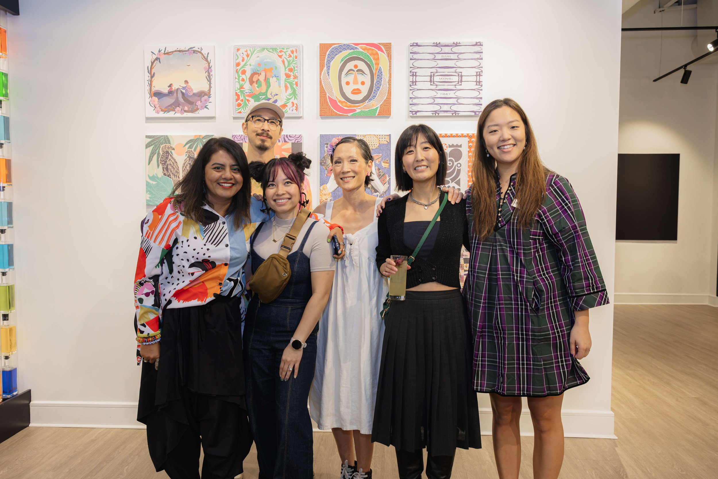 Asian American Artists from the Threads of Justice Project standing in front of artwork during the Threads of Justice exhibit opening reception. 