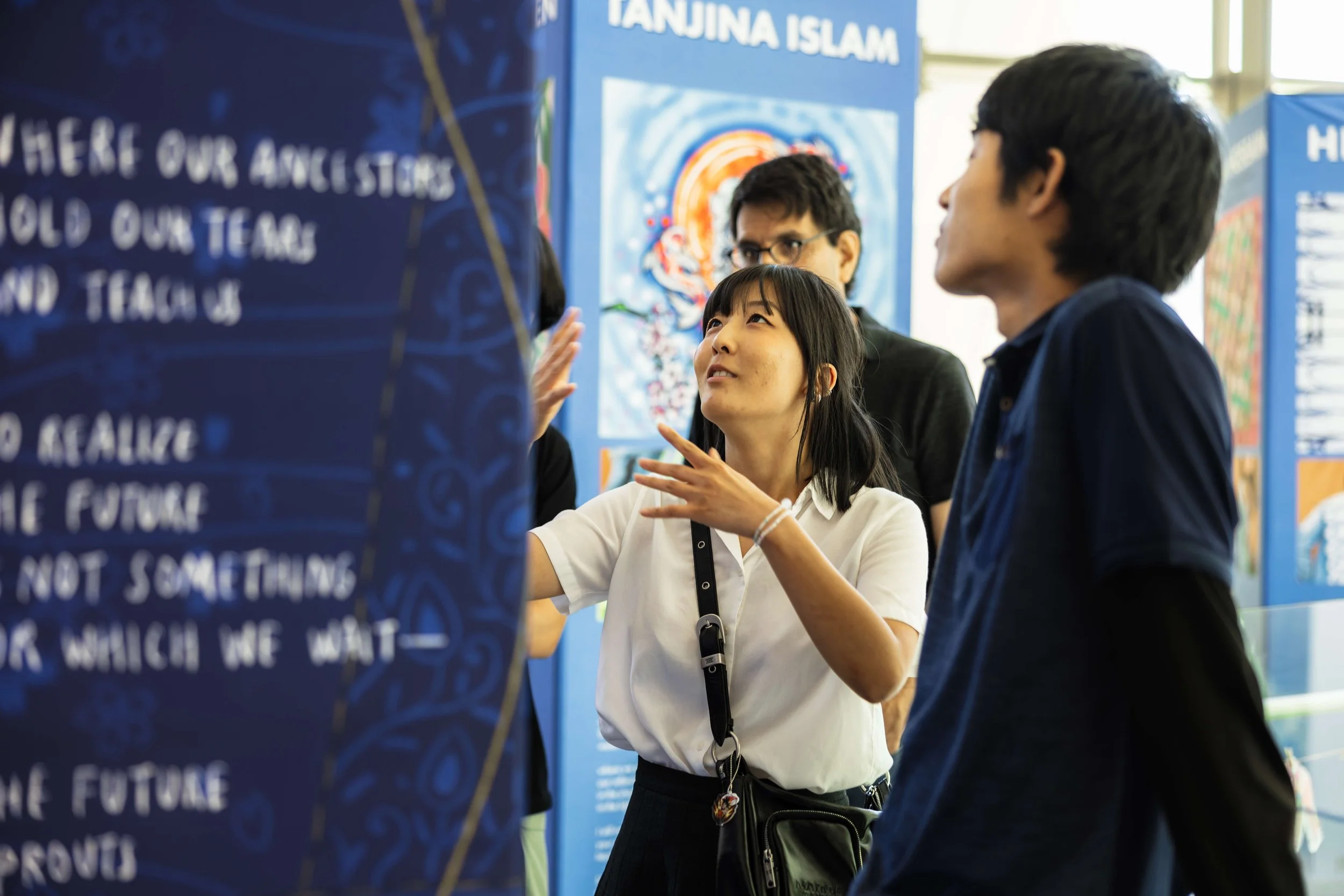 2024 Artist in Residence Gabby Lee explains her "Threads of Justice" artwork to community members during an exhibit at the National Center for Civic and Human Rights.