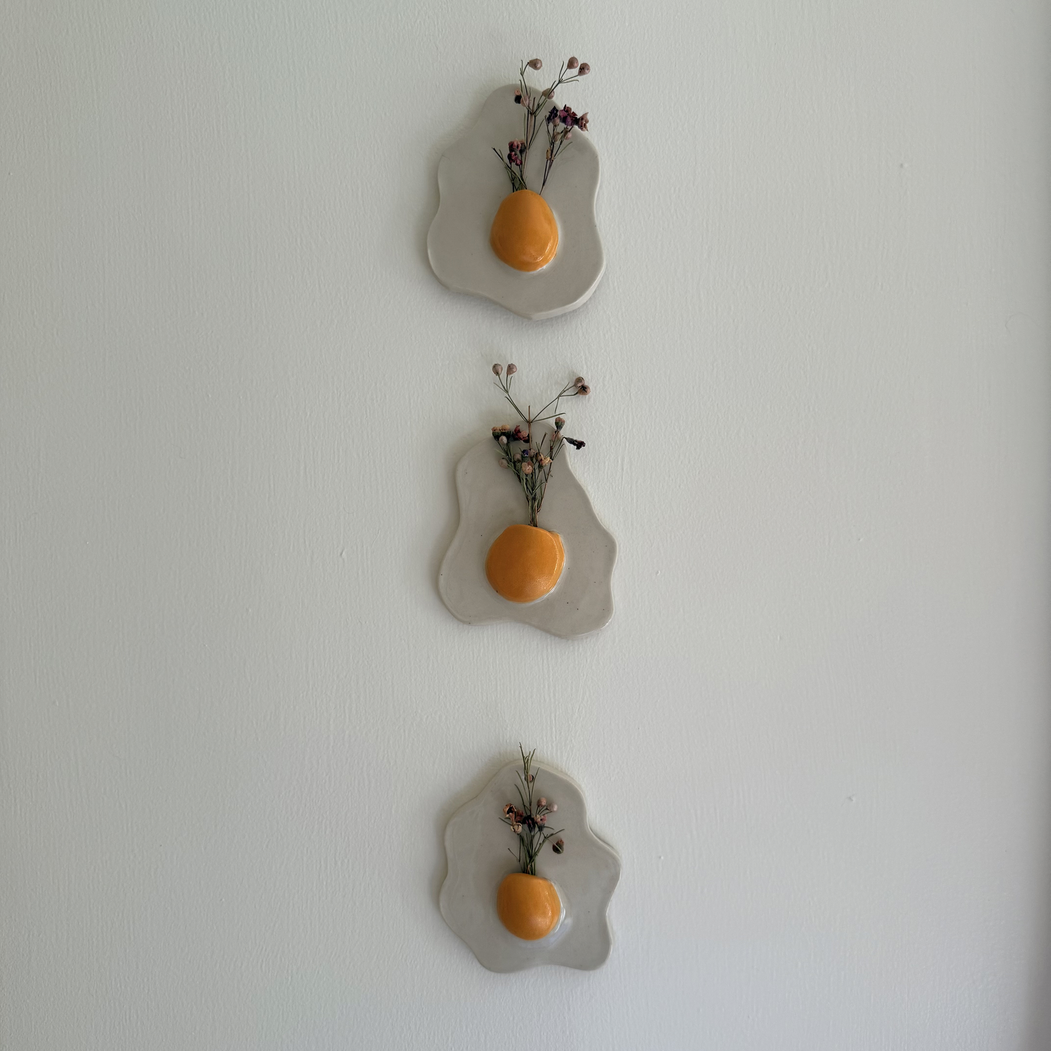 Three eggs on a wall.png