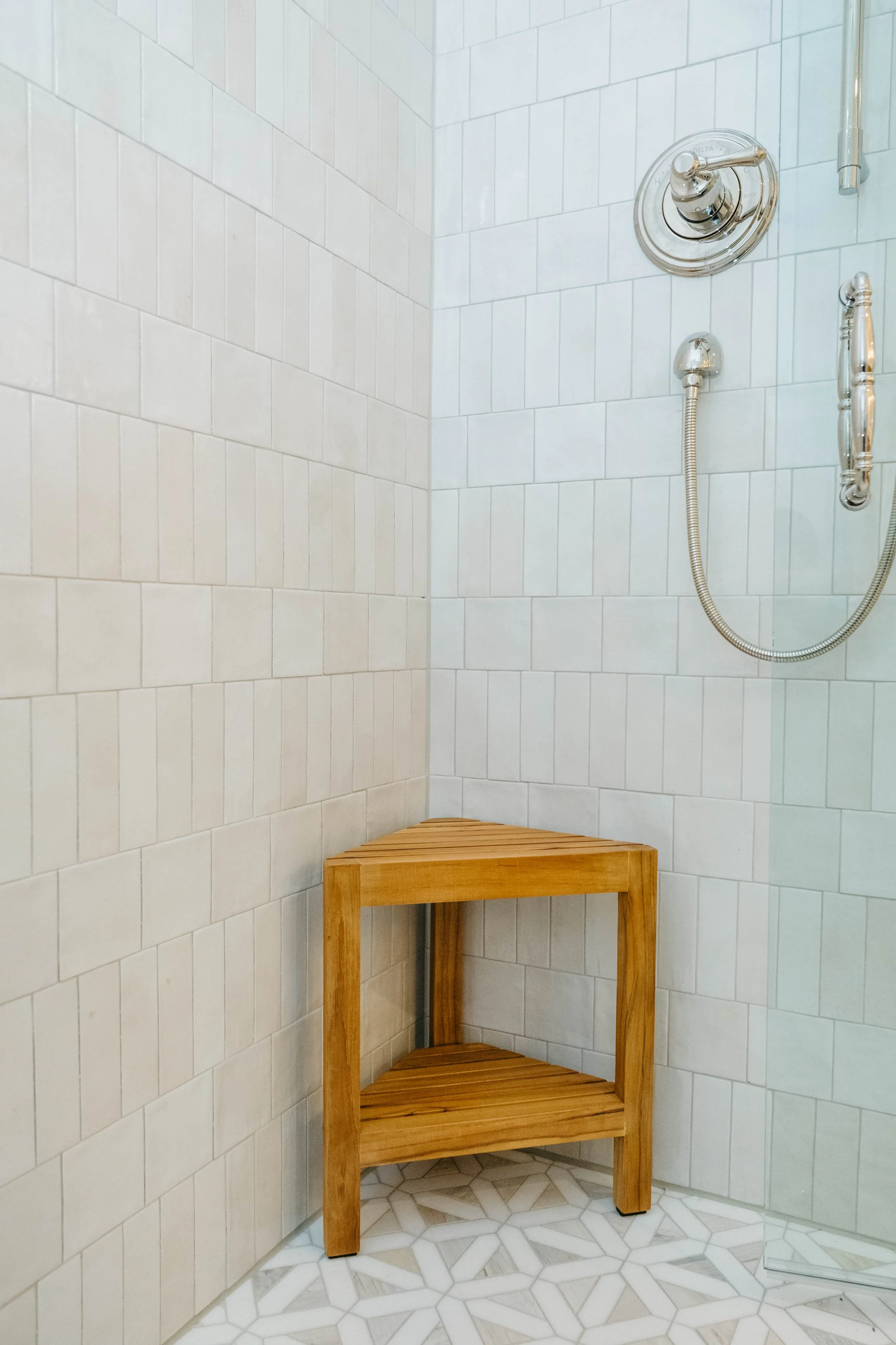 A shower area with unique shower wall tile layout.