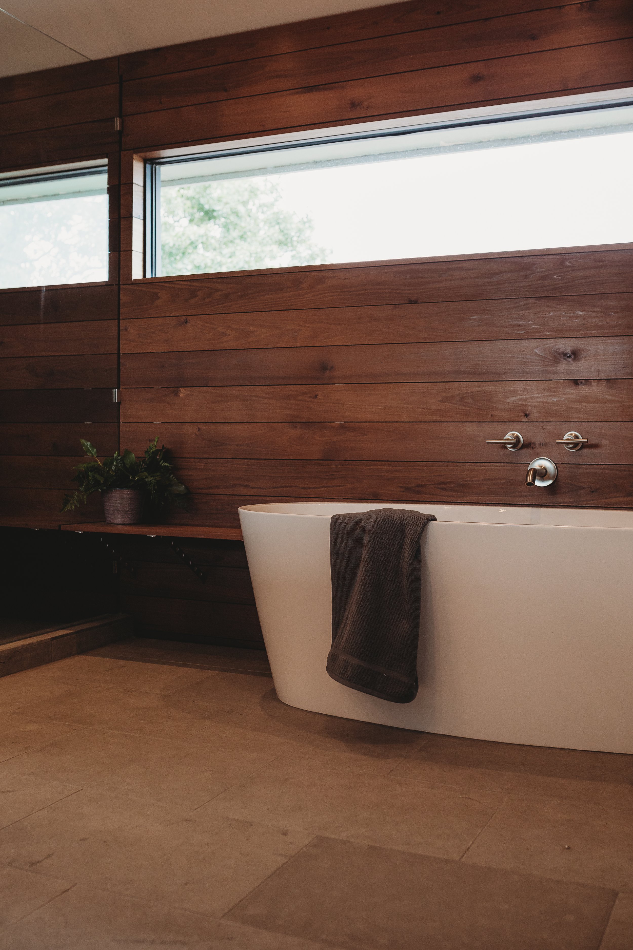 Freestanding tub with custom wood paneling.