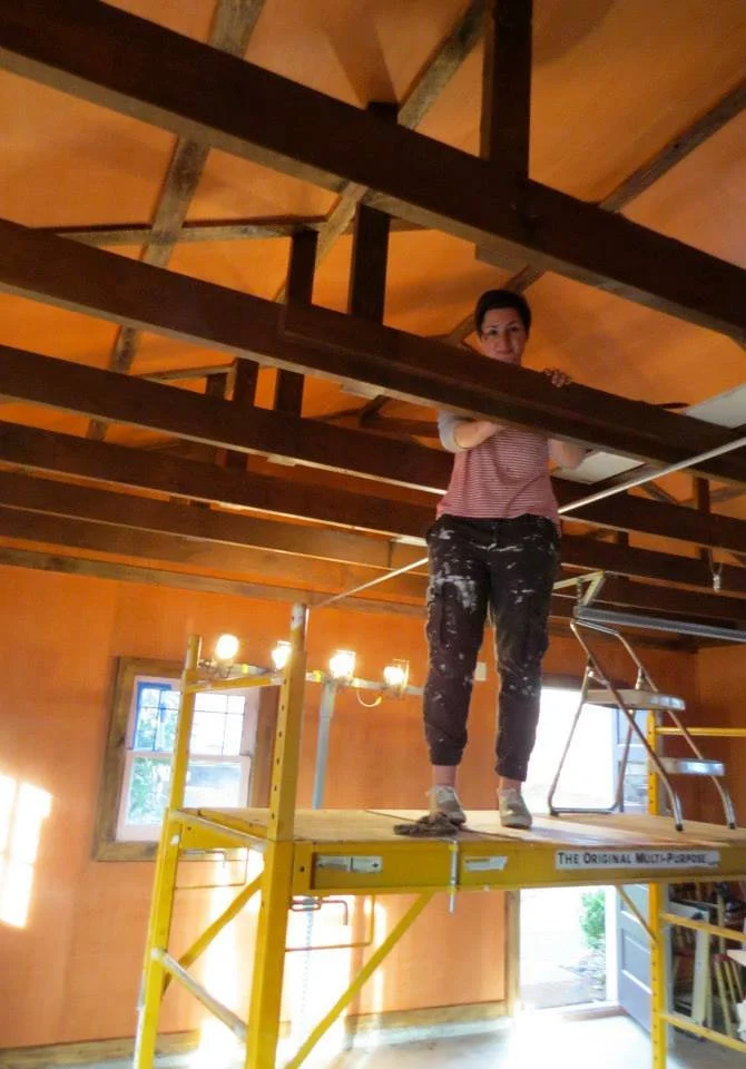 2014 - The Beginning: Jenny stains the wood beams in they early days of the studio