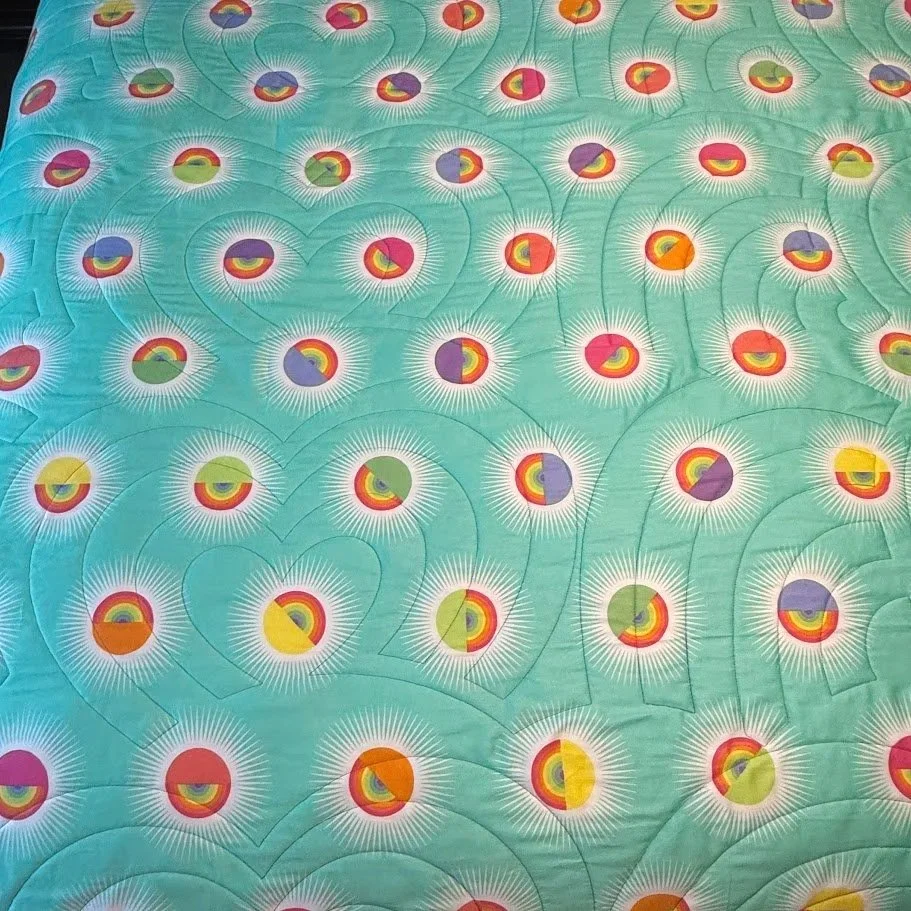 Colorful circular patterns on a teal background, resembling stylized flowers with radiating lines.