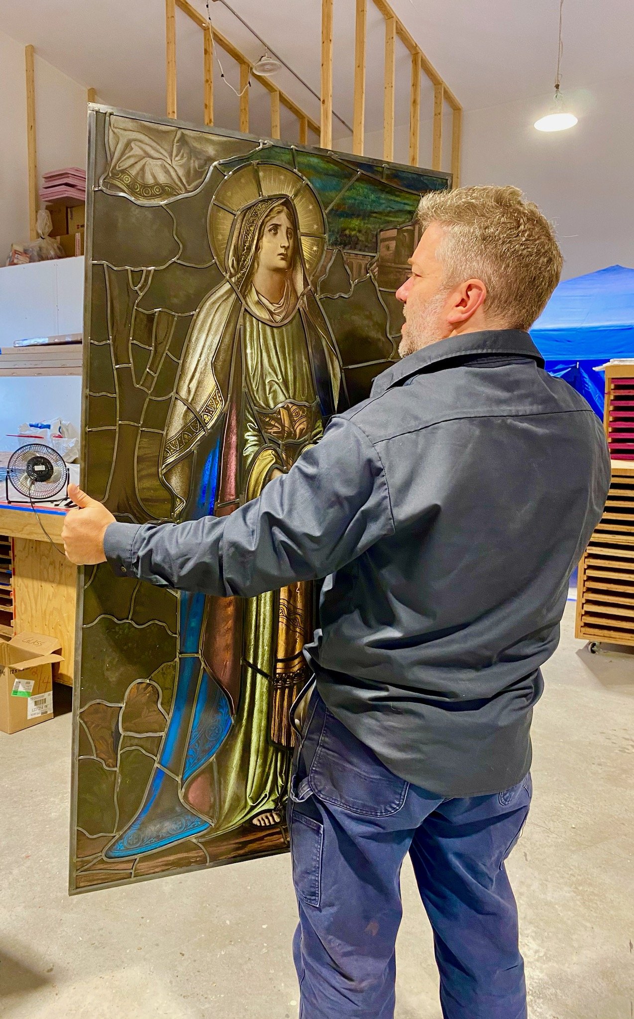 Figurative stained glass panel during conservation work
