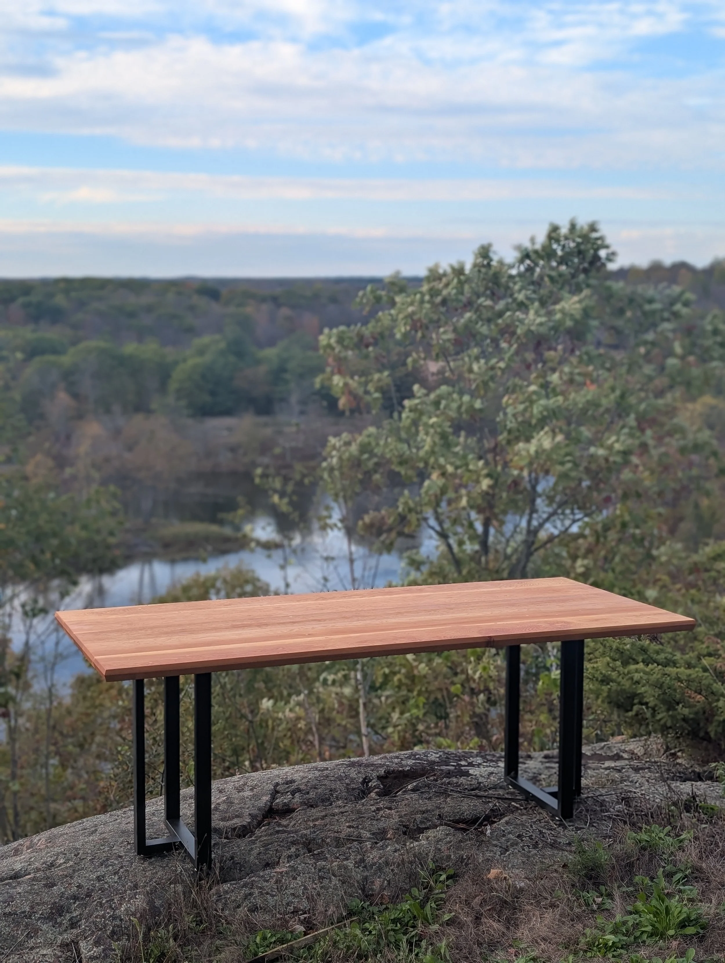 Custom solid wood table with steel base, fabricated by Parallel Studios and photographed outdoors in Eastern Ontario.