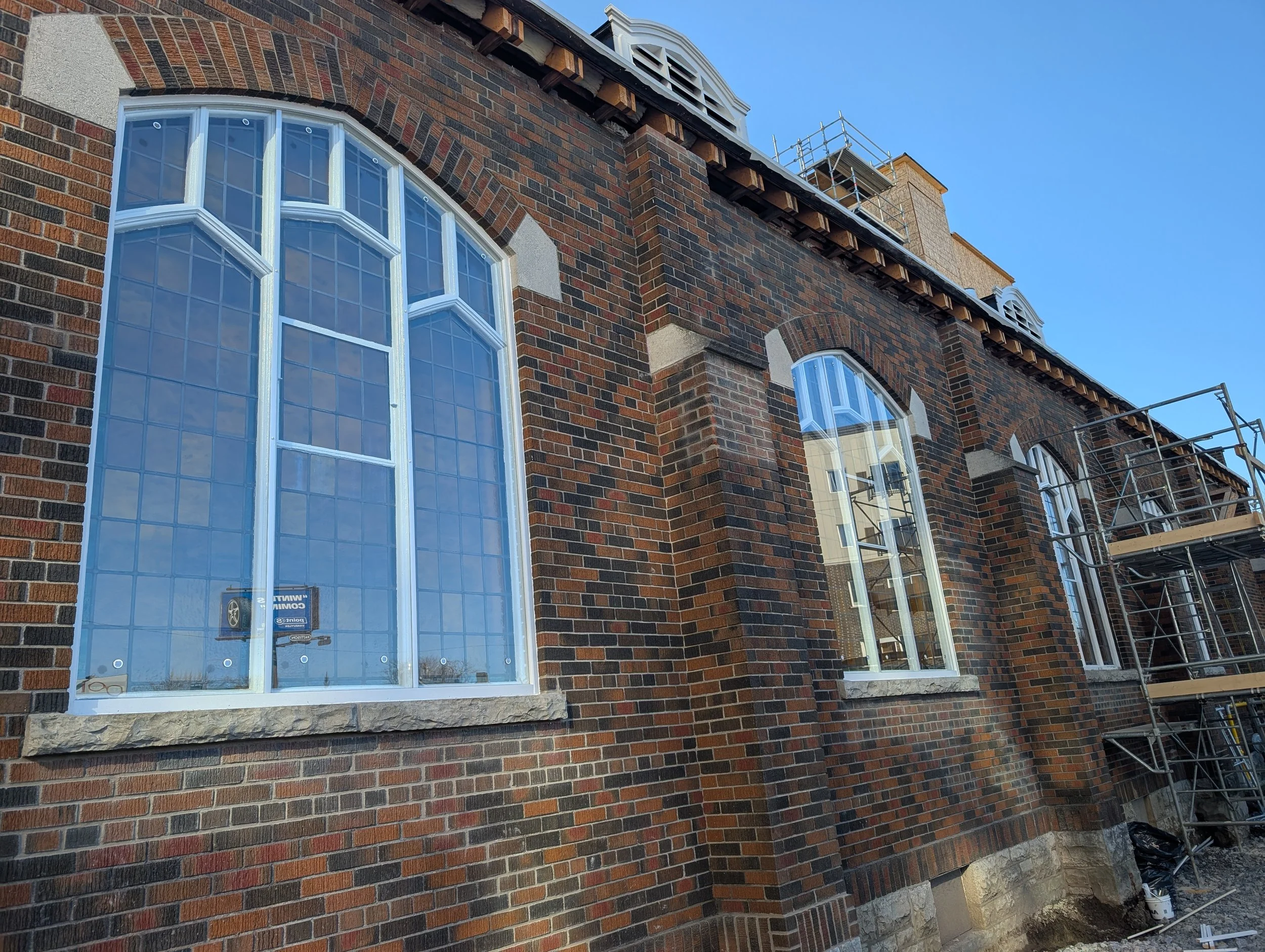 Historic brick building with arched windows during restoration work

