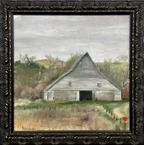 A painting of a gray barn with a triangular roof, situated on a farm with green grass, some trees in the background, and a cloudy sky overhead.
