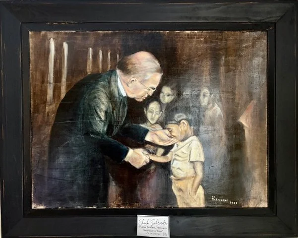 An adult man, possibly a teacher or mentor, shows something in a book or folder to a group of children, including a boy in a beige shirt, inside a dimly lit room with dark wooden walls.