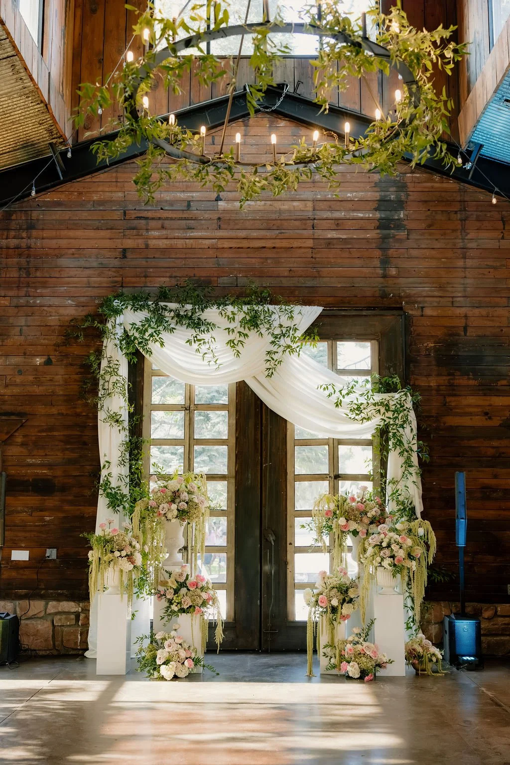 A breathtaking display of luxury wedding florals by Blooms by Tesla for a high-end celebration in Alpine, Utah. This design features a lush, romantic blend of creamy white roses, soft blush peonies, and delicate sweet peas, creating a timeless pink a