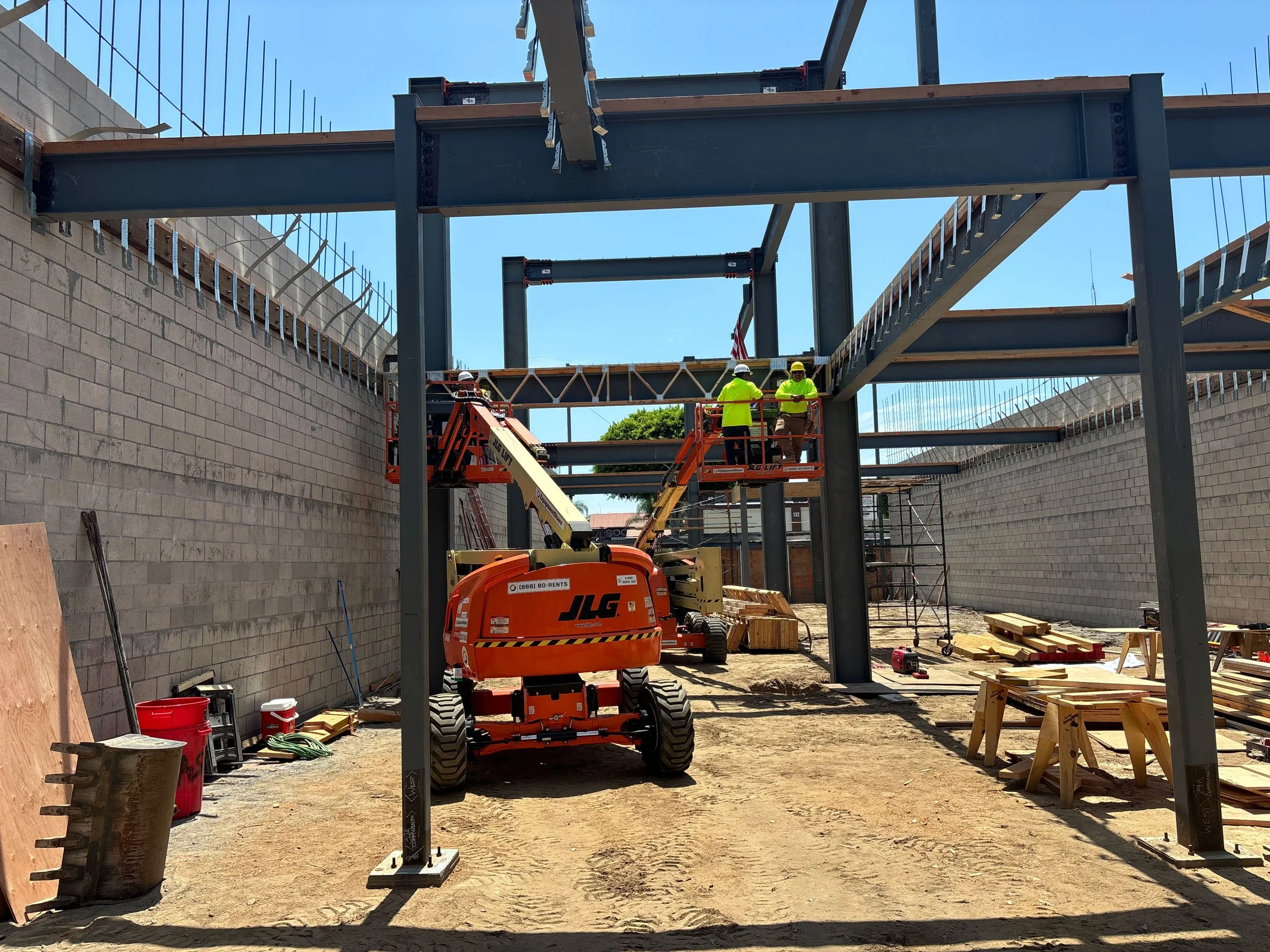 two men on a piece of equipment on a job site