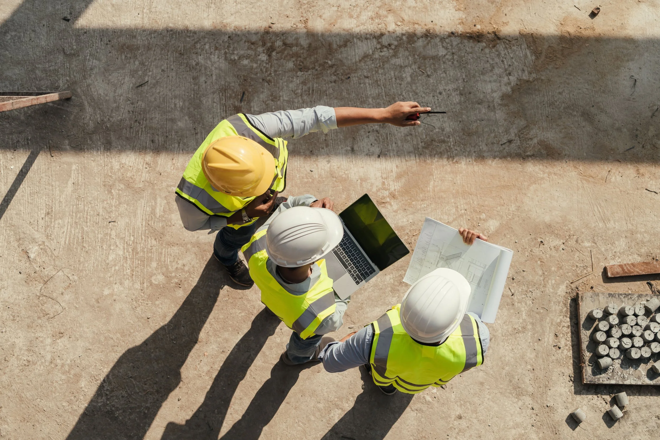 three men on construction job site wearing personal protective equipment to demonstrate safety
