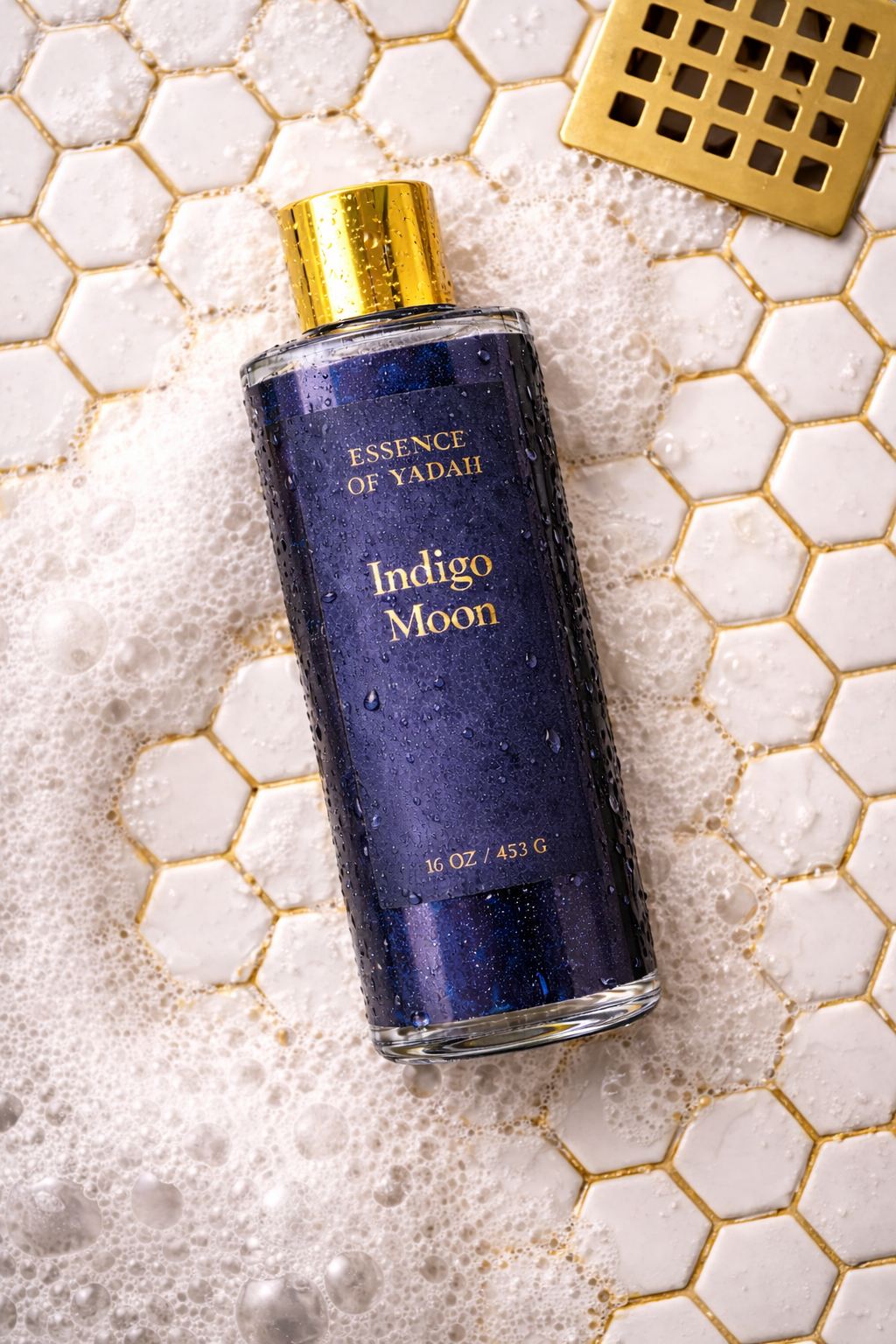 Indigo Moon body wash on white octagon tile with gold toned grout soap suds and brass drain Essence of Yadah