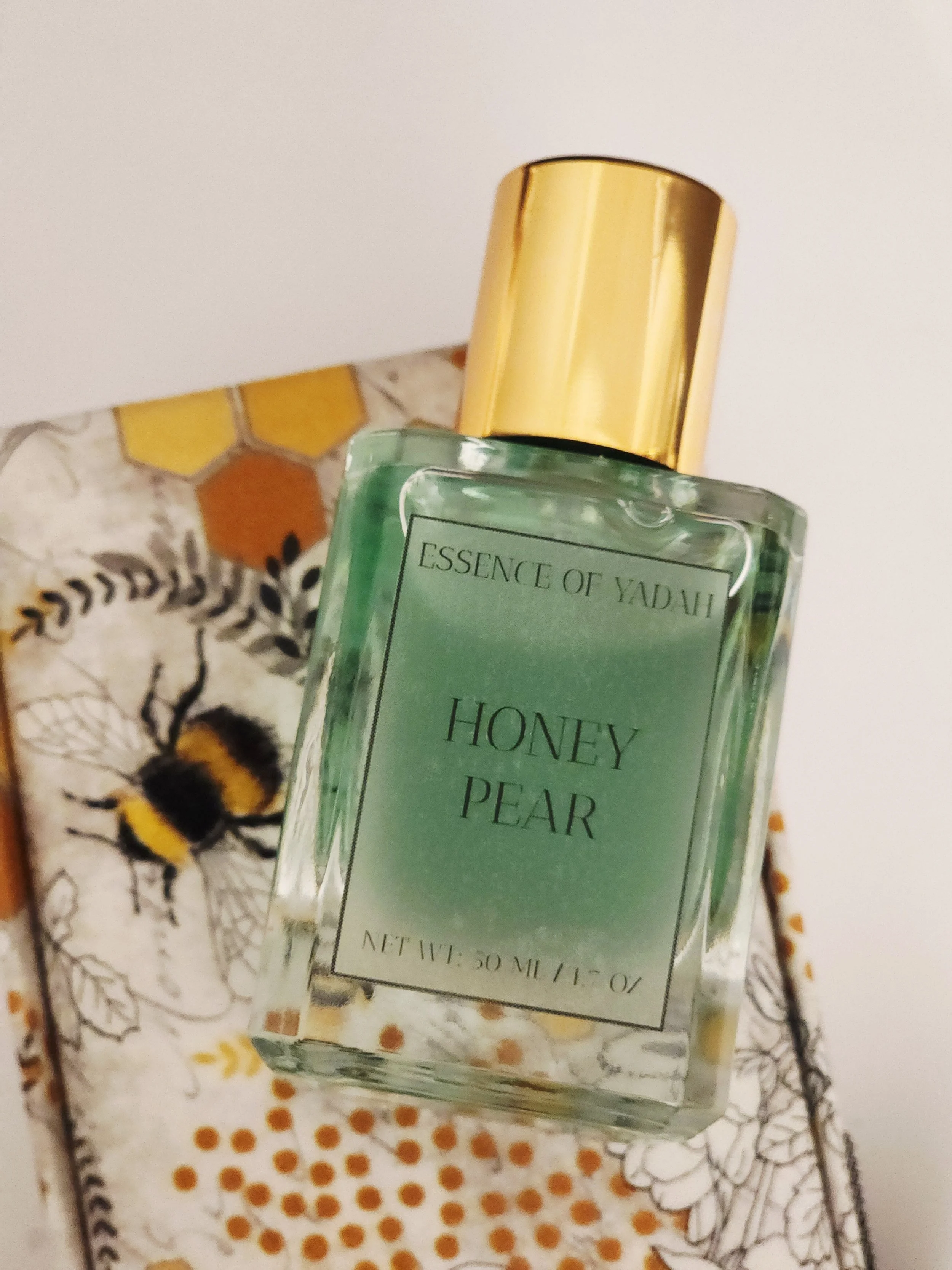 Honey pear in square bottle flat lay on custom bee box white background Essence of Yadah.jpg