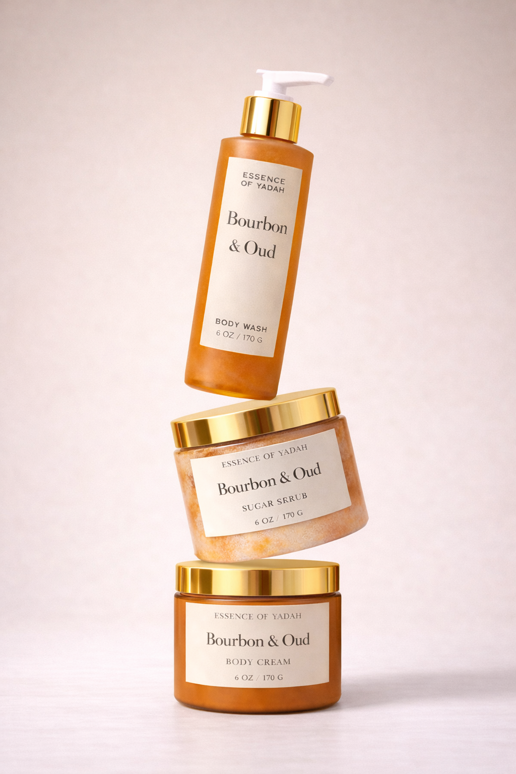 Bourbon & Oud skincare set which includes body wash, sugar scrub, and body cream, the bottles appear to float in mid-air against a neutral background.