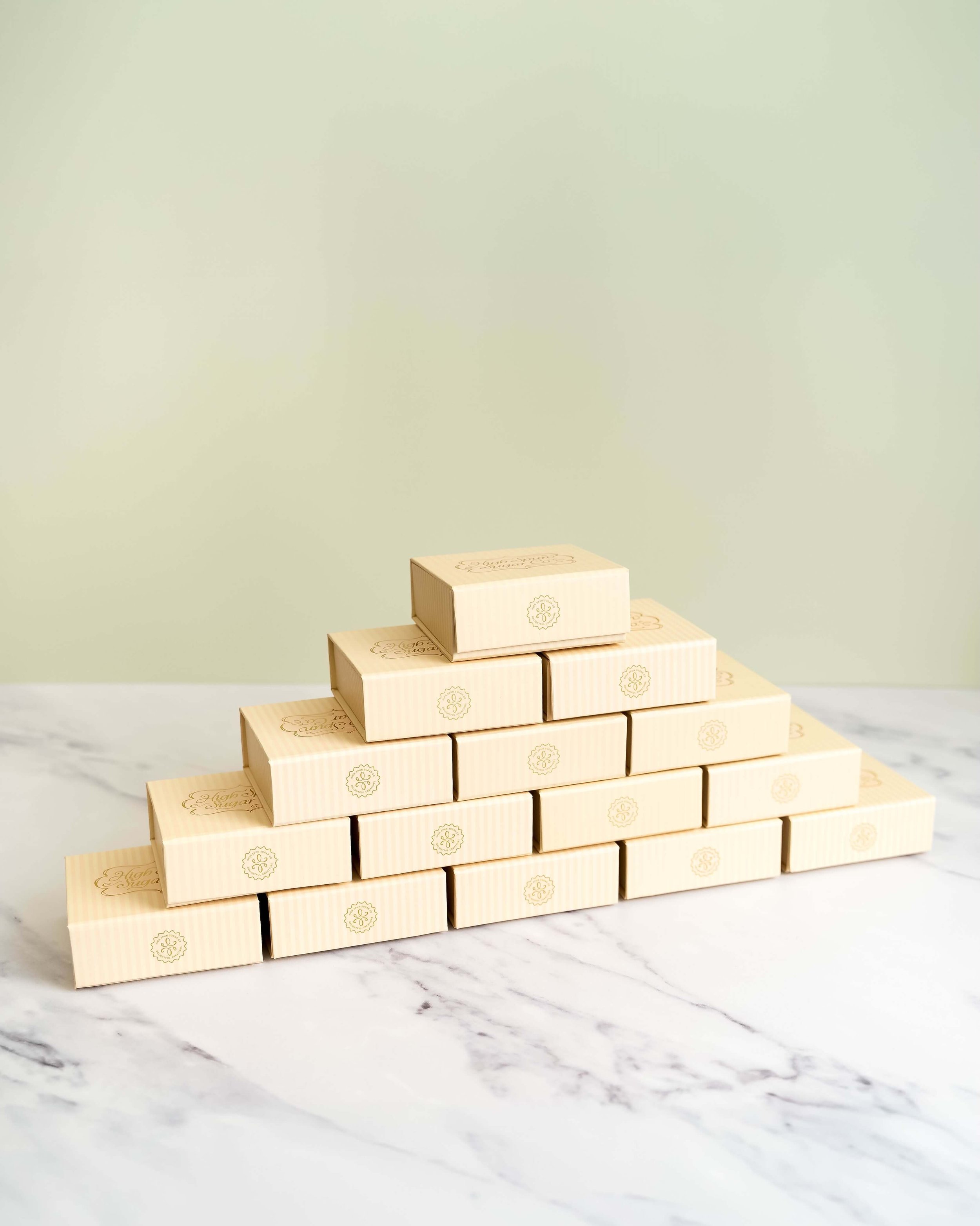 Stacked, beige bite-sized boxes before an olive green background