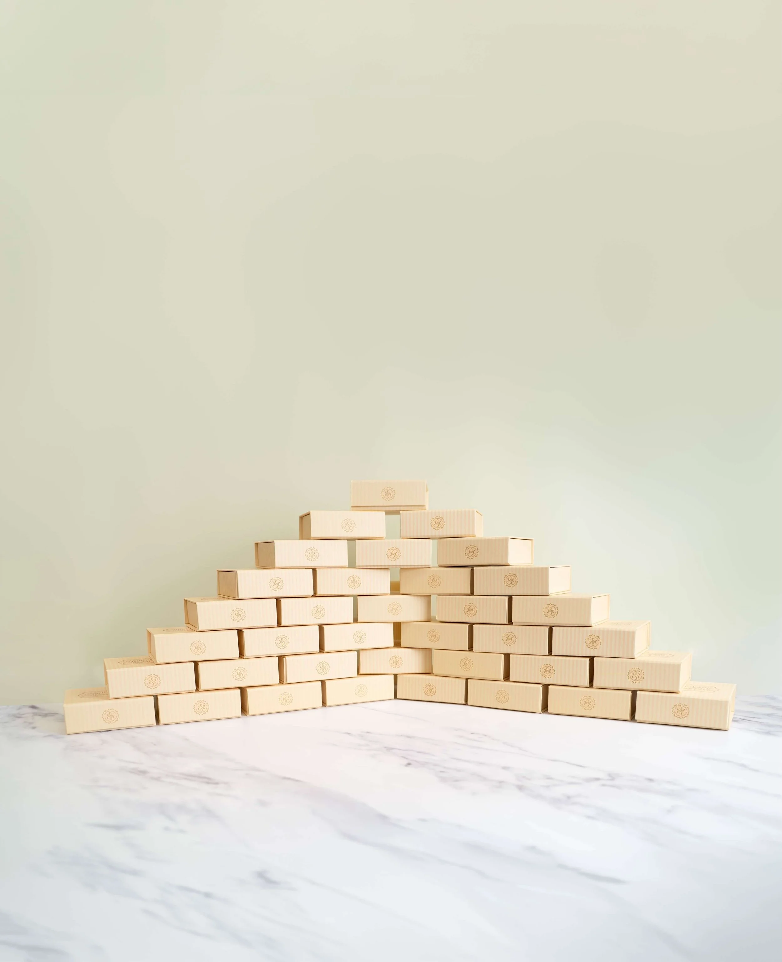 Stacked, beige bite-sized boxes before an olive green background