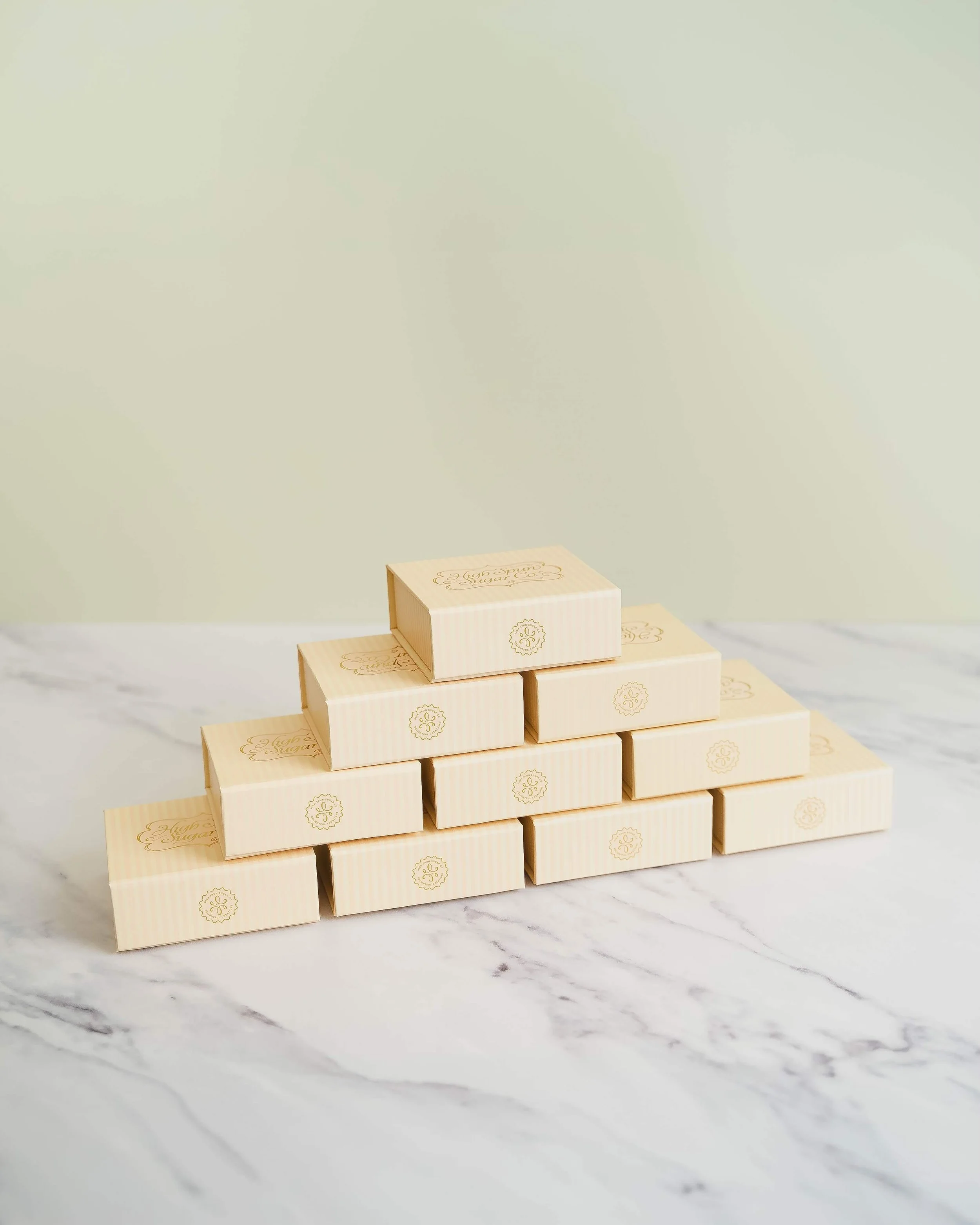 Stacked, beige bite-sized boxes before an olive green background