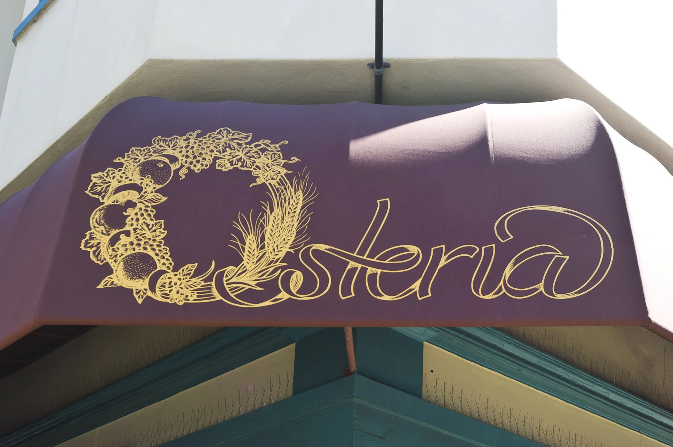 Purple awning with gold lettering that reads "Cesteria" and a decorative grapevine and wheat design.
