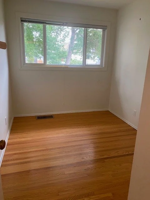 Freshly cleaned bedroom with dusted surfaces and vacuumed carpet, serviced by AAE Home Glow in Calgary.