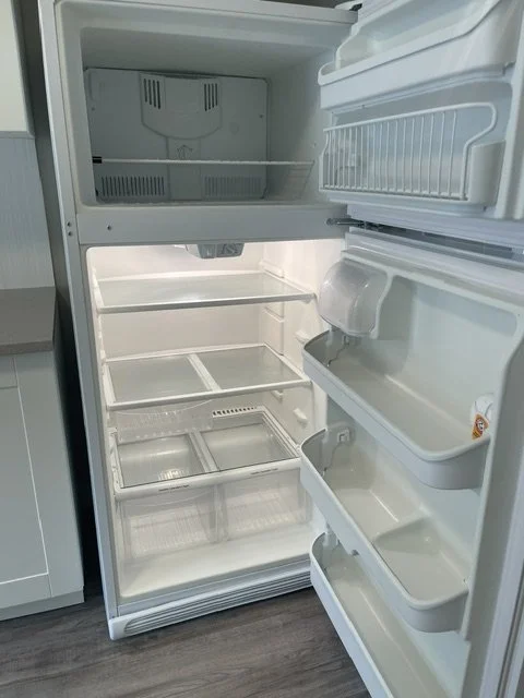 Empty fridge shelves and drawers scrubbed spotless as part of a move-out cleaning service by AAE Home Glow