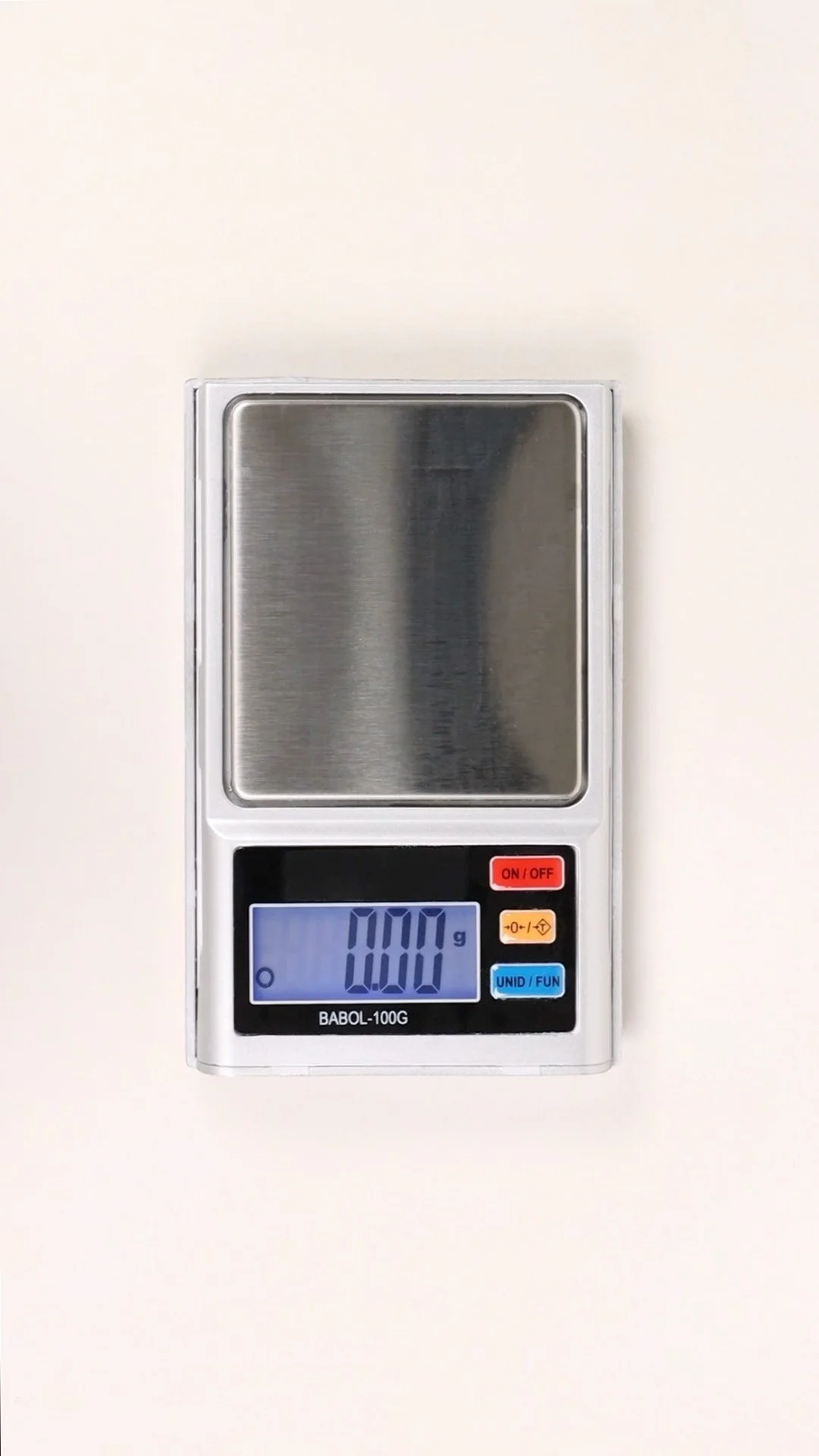 Balanza digital en una superficie blanca, apagada con la pantalla que muestra 0.00 gramos.