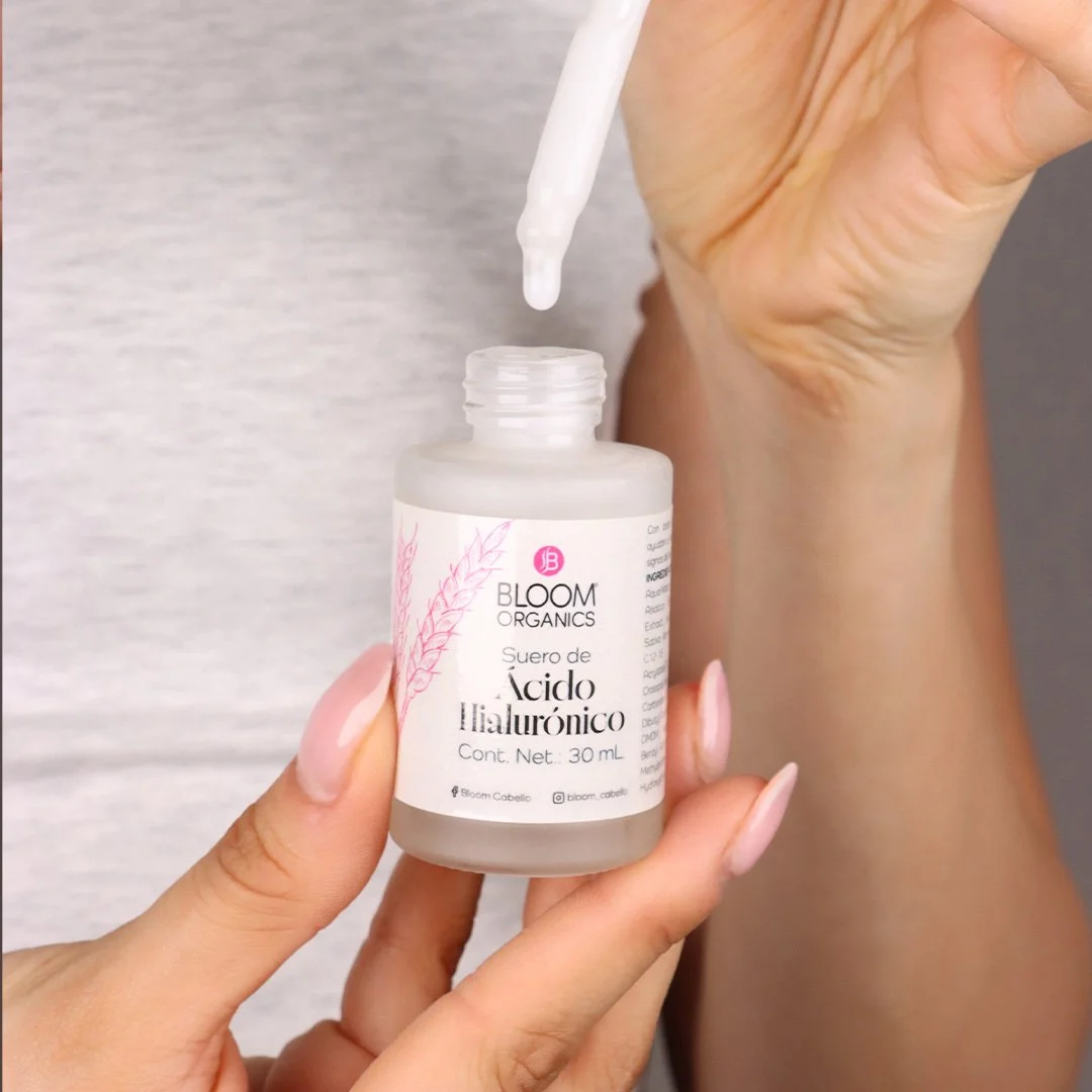 Mano sosteniendo un frasco de 30 ml de suero de ácido hialurónico con un gotero.