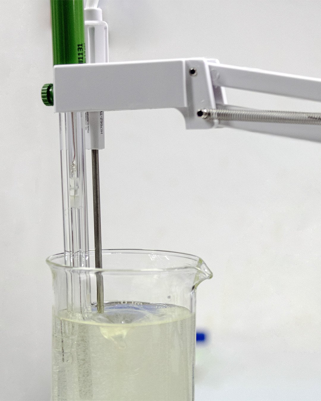 Un equipo de laboratorio mide la temperatura en un vaso con líquido transparente.