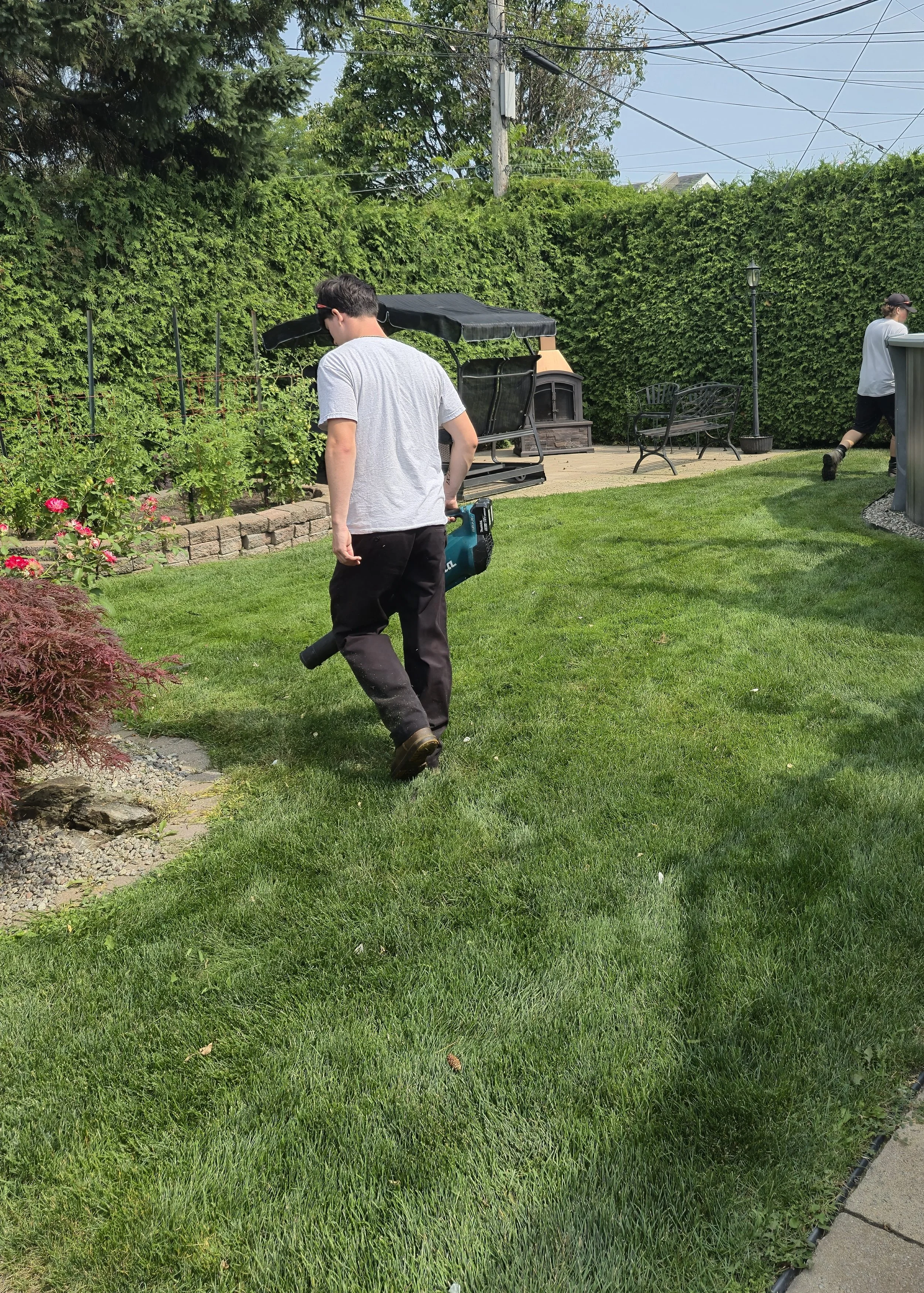 Employé de Guillaume Gazon effectuant le soufflage et le nettoyage d’un terrain après la tonte de pelouse résidentielle à Sainte-Julie