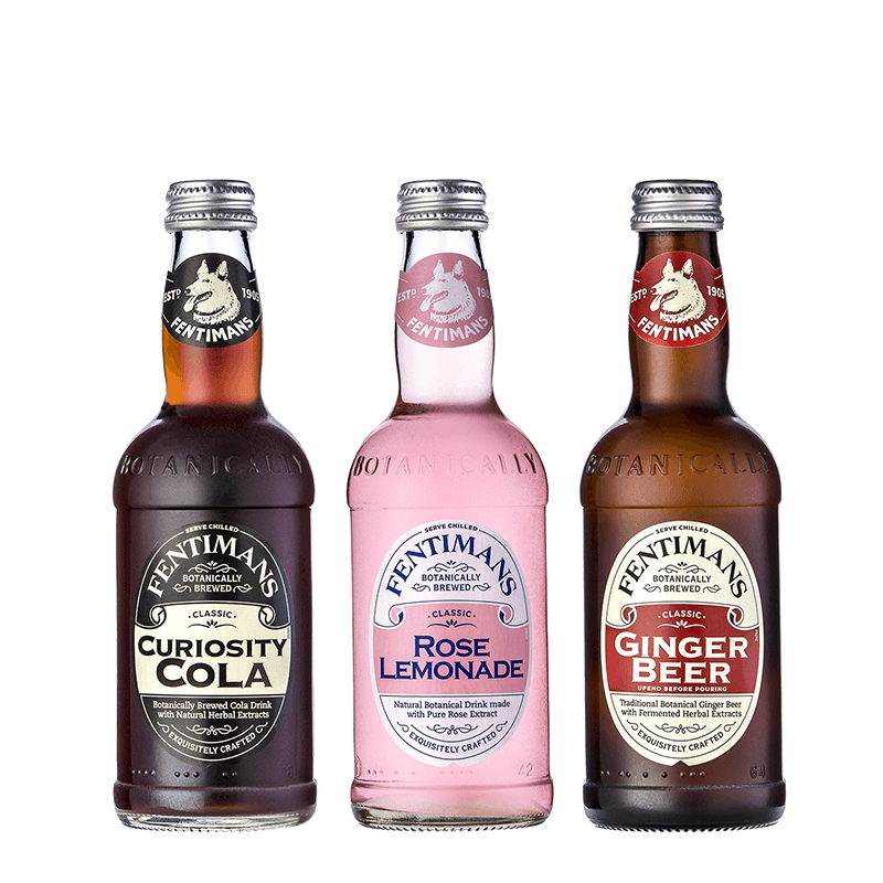 Three bottles of flavored beverages from Fentimans, including Curiosity Cola, Rose Lemonade, and Ginger Beer, arranged in a row on a black background.