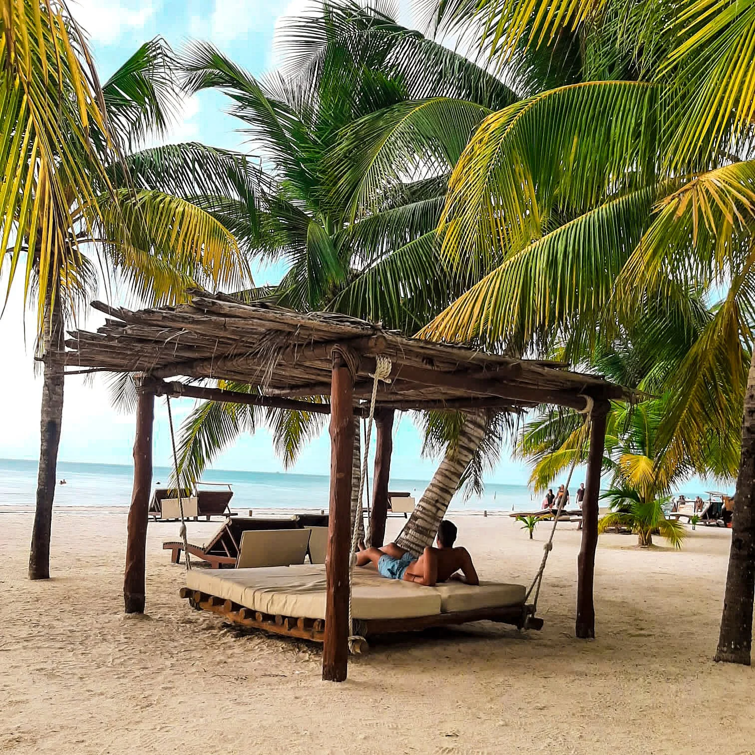 Chico tumbado en playa de Holbox en Mexico