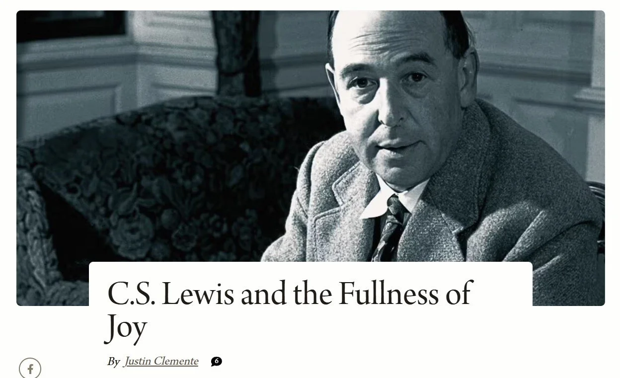 Black and white photo of C.S. Lewis sitting on a couch in a room with decorated walls, wearing a suit and tie.