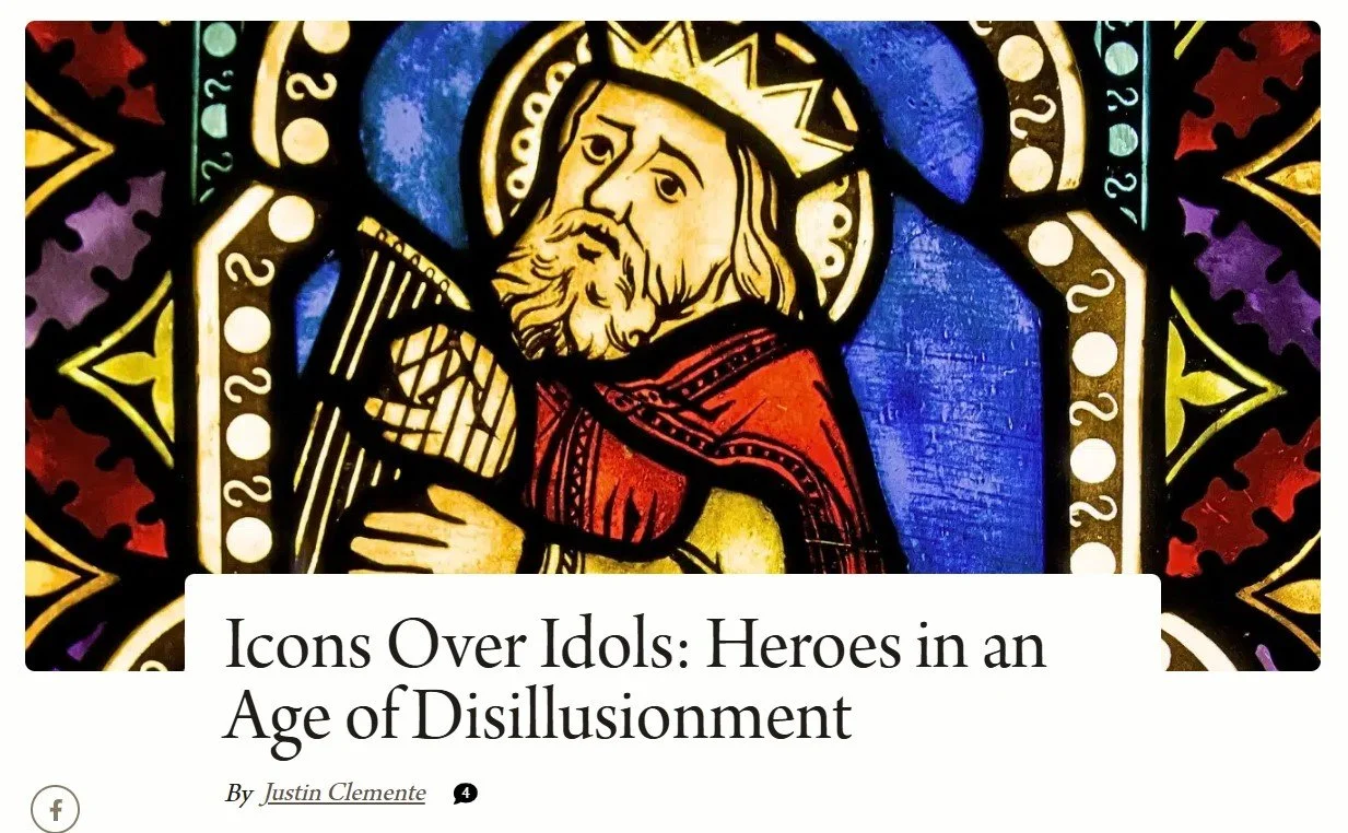 Close-up of a stained glass window depicting a figure with a crown, beard, and red cloak holding a harp.