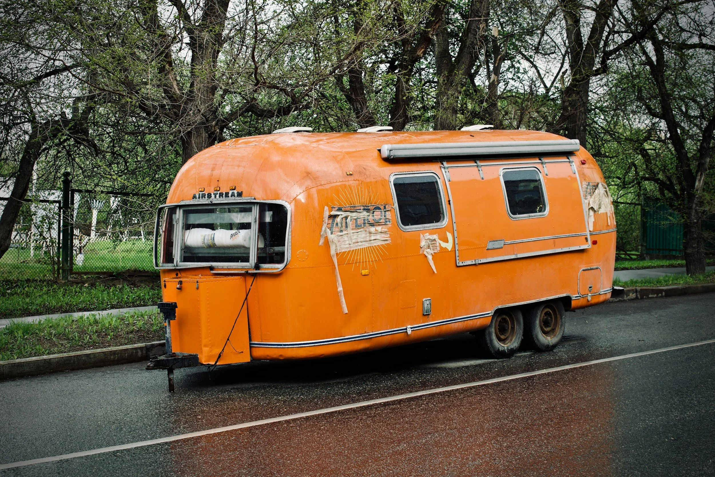 An old, orange camper trailer waiting for transport or move