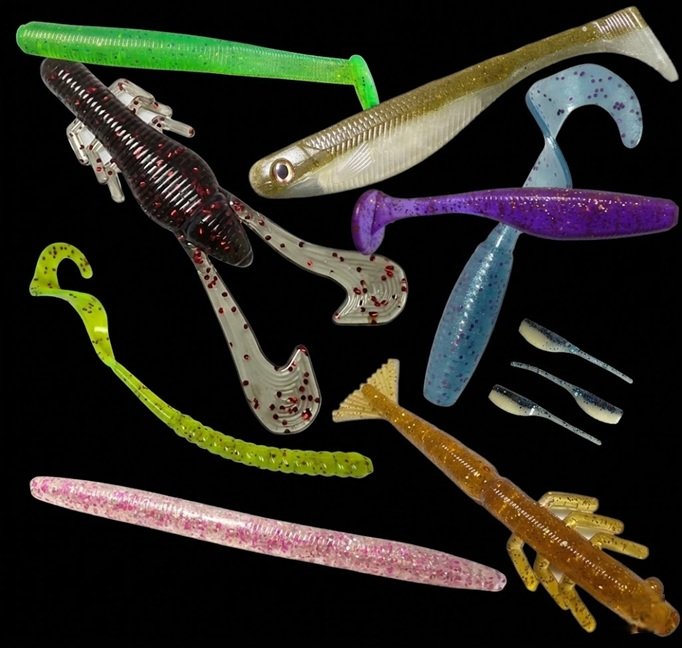 A variety of colorful soft plastic fishing lures in different shapes and sizes arranged on a black background.