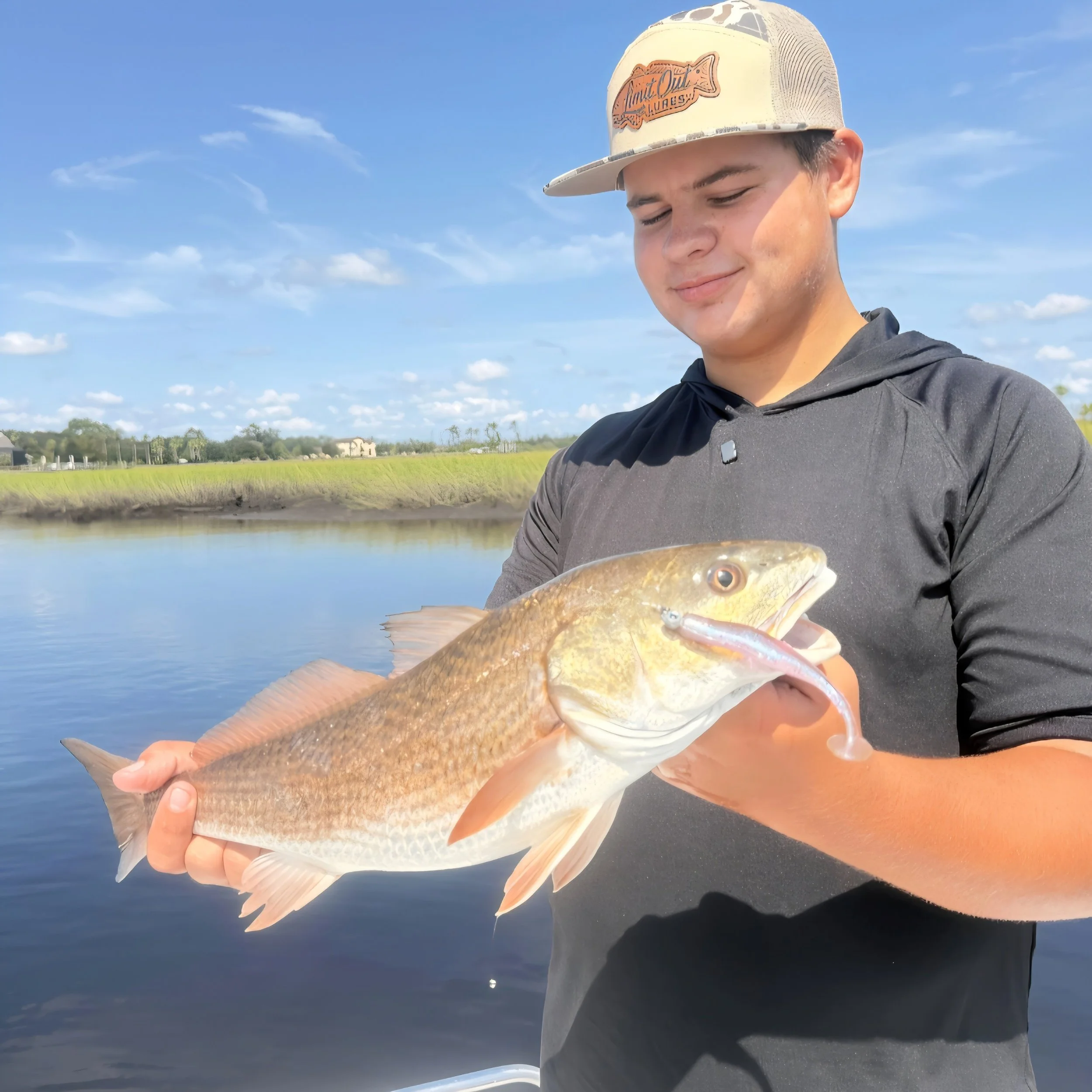 angler in limit out lures hat holding redfish he caught using the 3.8 prism glider paddle tail
